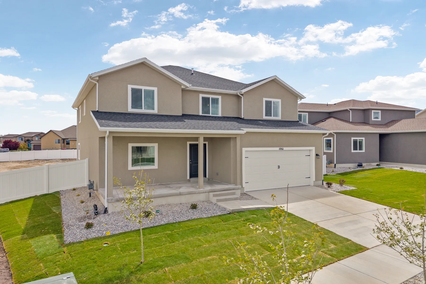 Contemporary two-story residence featuring a stucco exterior and a covered front porch