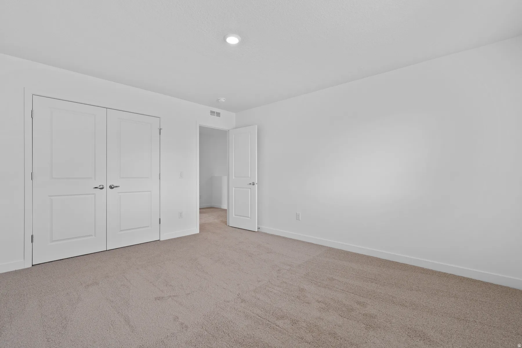 Carpeted room with a recessed ceiling light