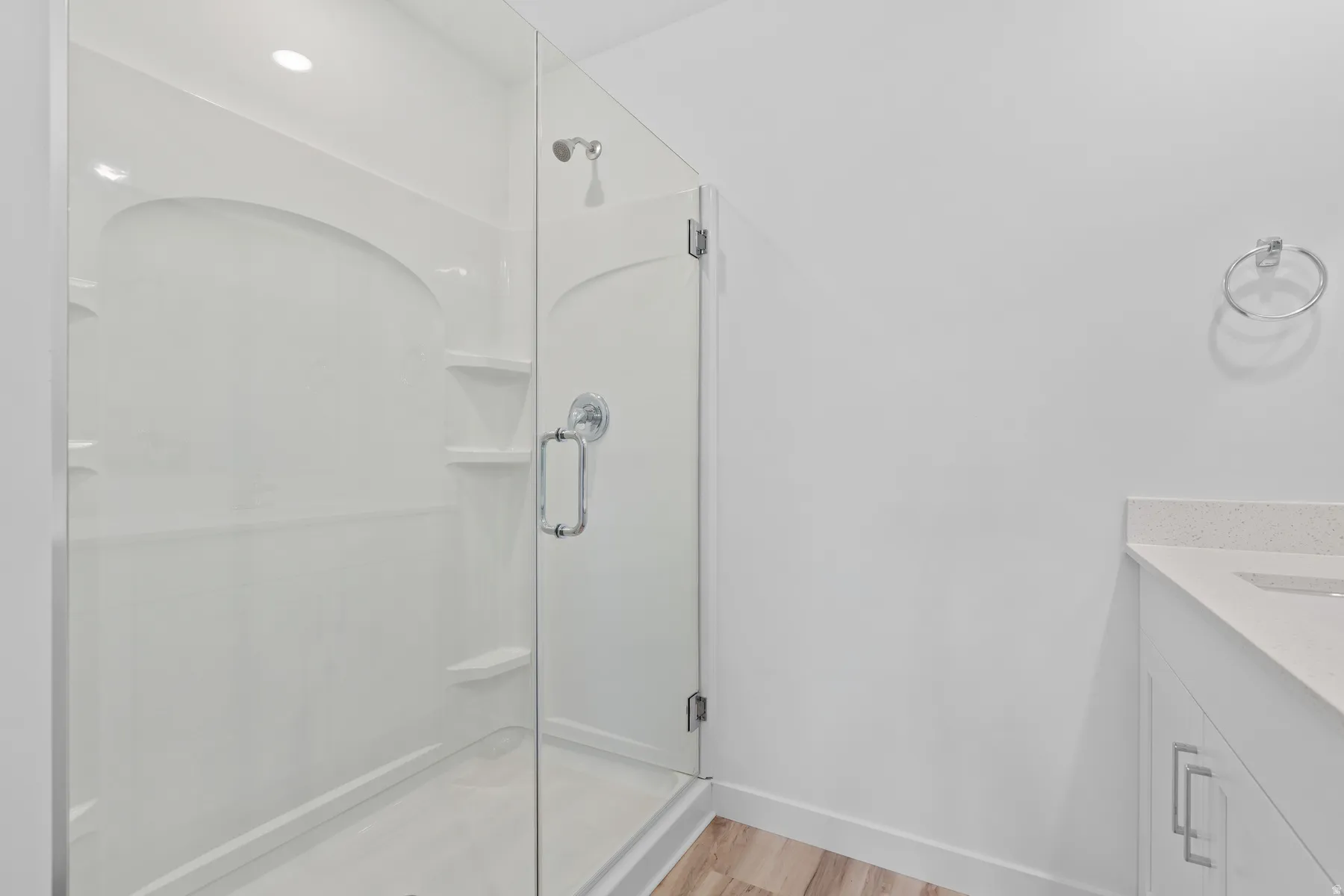 Modern walk-in shower featuring a clear glass enclosure and a chrome shower head