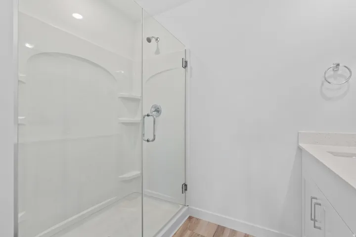 Modern walk-in shower featuring a clear glass enclosure and a chrome shower head