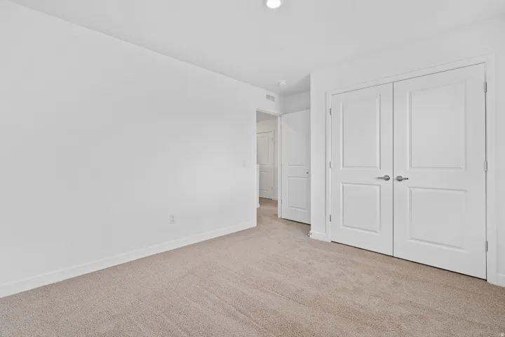 Neutral-toned carpeting paired with white baseboards and walls