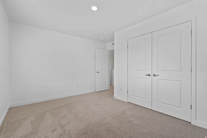 Neutral tone-on-tone carpet flooring complements the crisp white walls