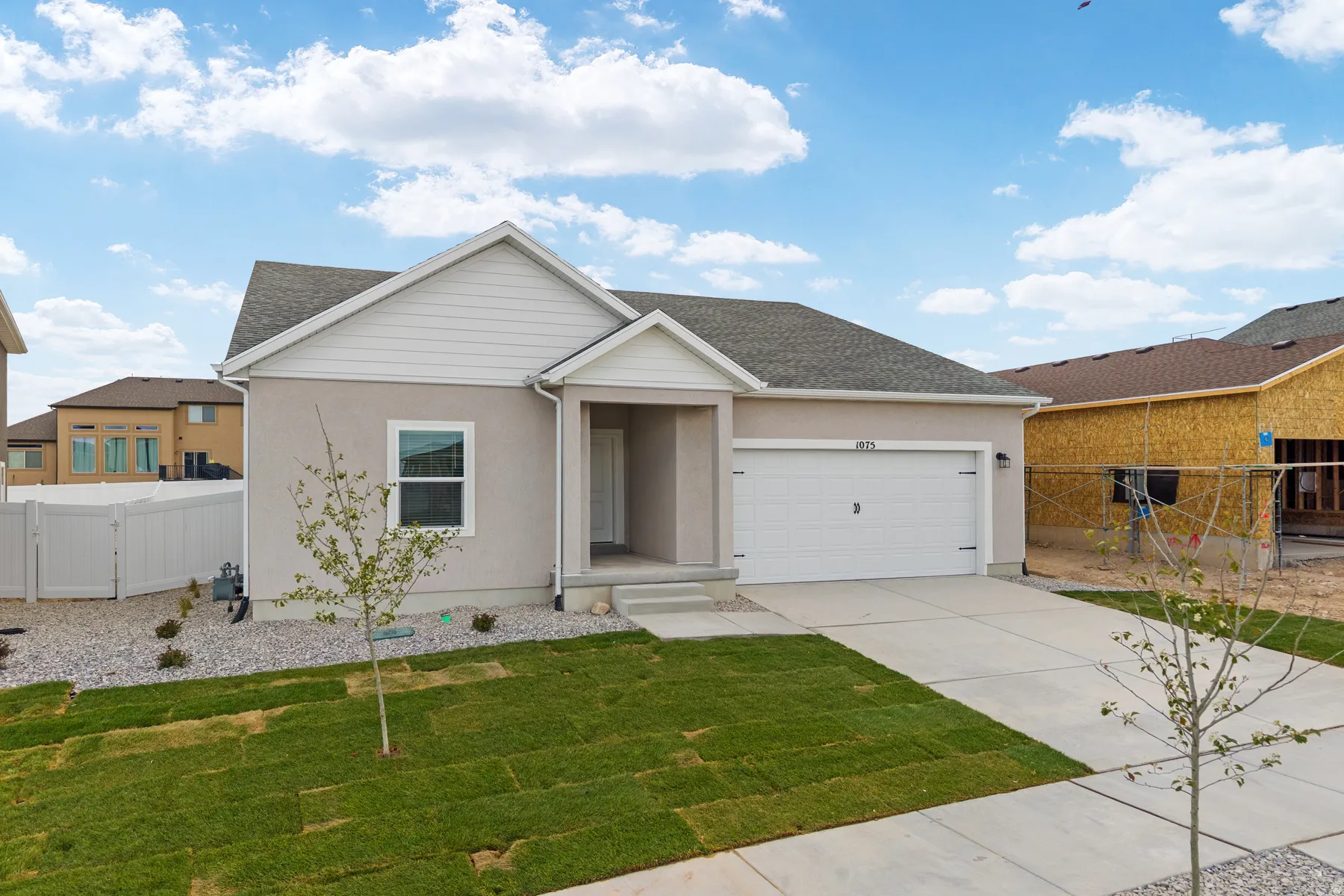 Contemporary single-story residence featuring a stucco exterior and pitched shingle roof