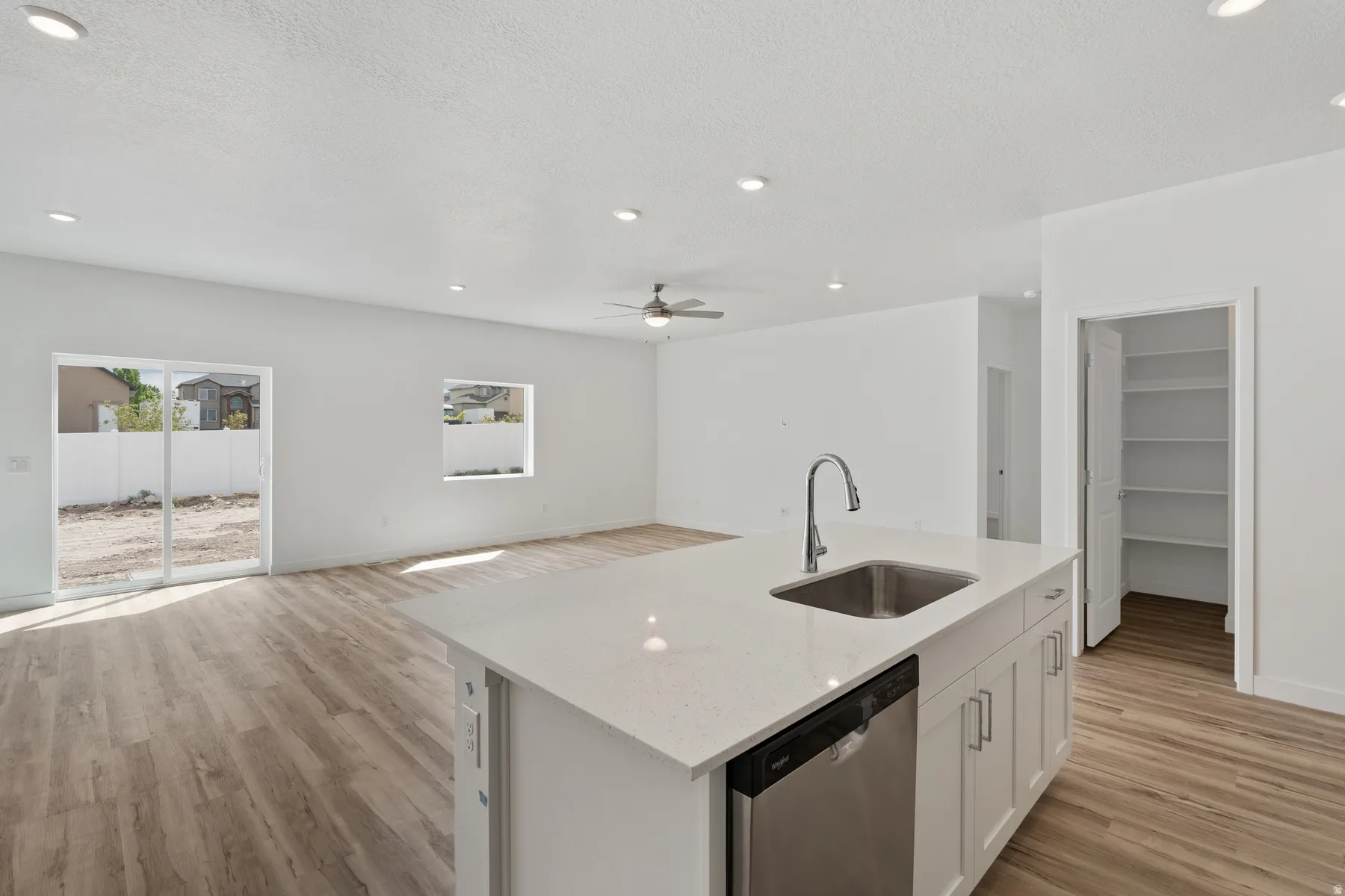 Modern kitchen island with a stainless steel sink, gooseneck faucet, and integrated dishwasher
