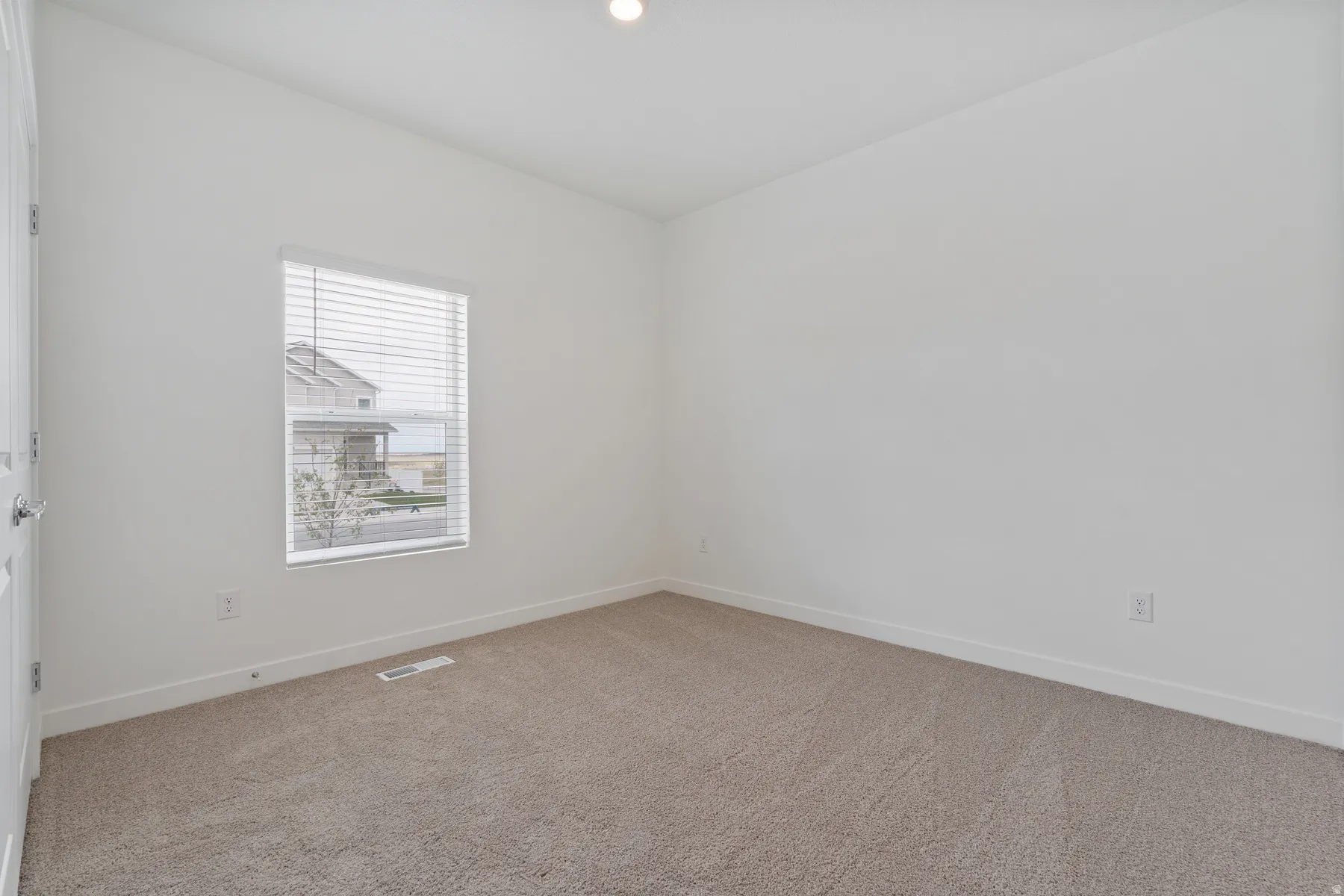Neutral-toned carpeting and white walls in a bright interior room