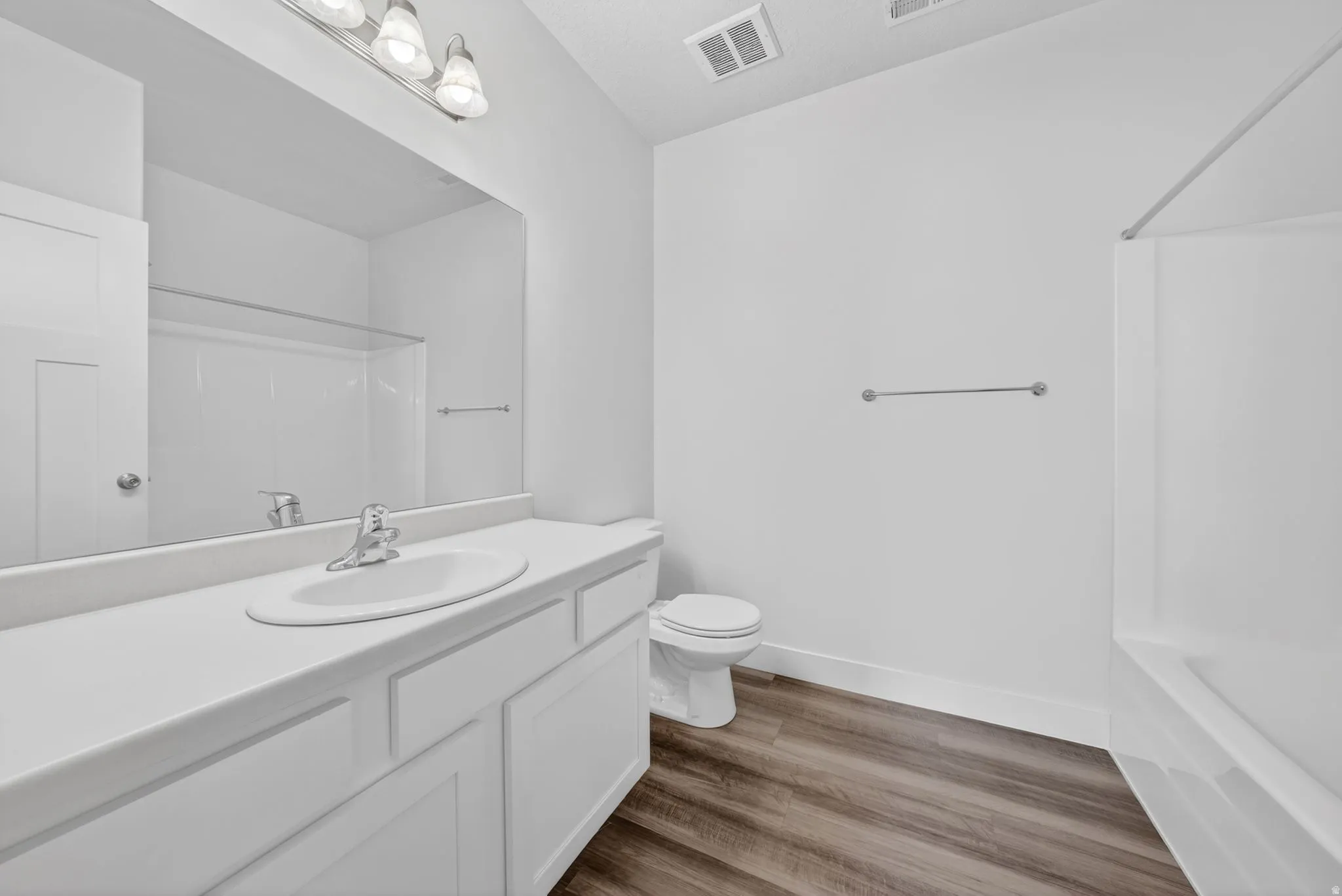 Full bath featuring vanity, dark wood finished floors, and bathtub / shower combination