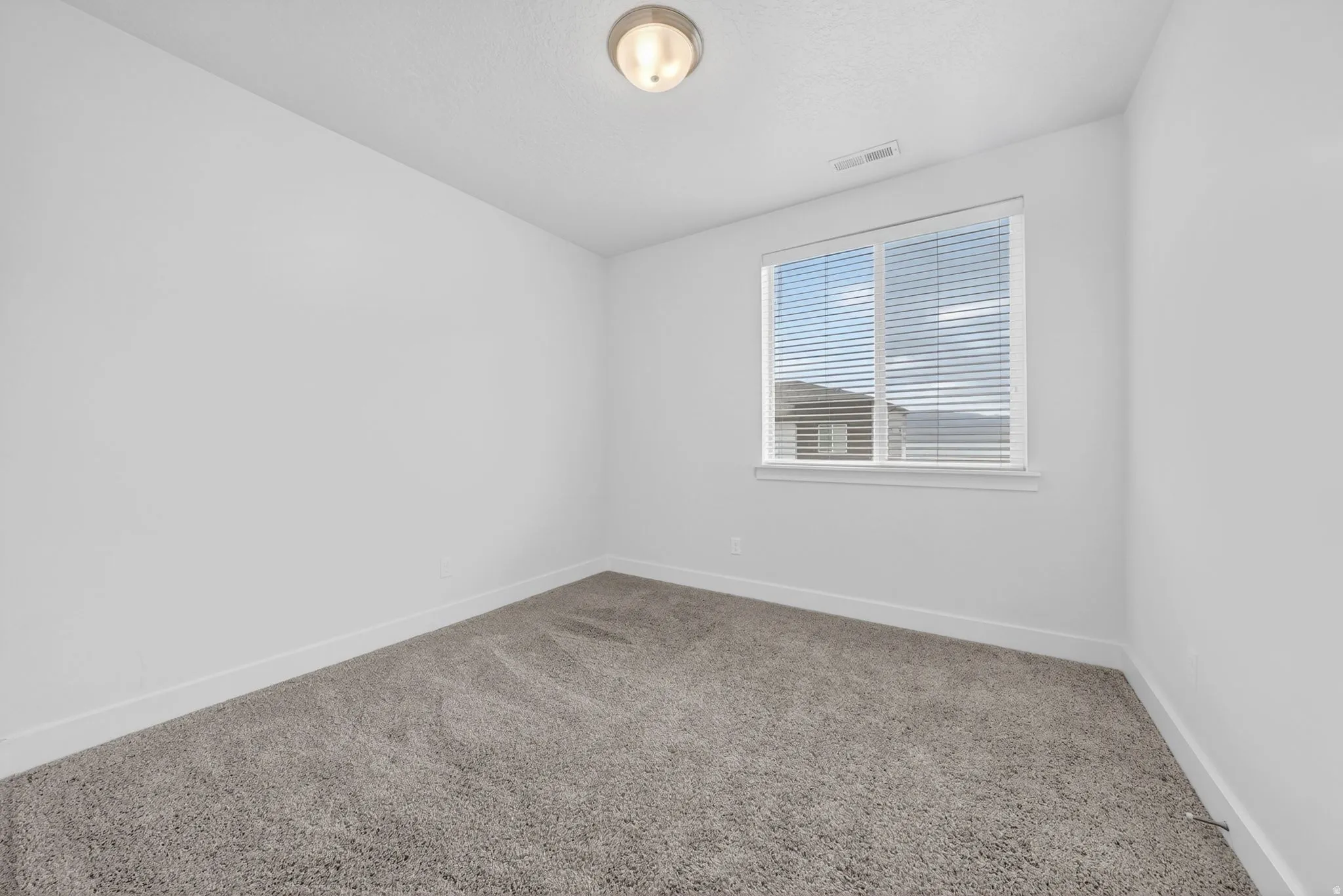 Unfurnished room with carpet and a textured ceiling