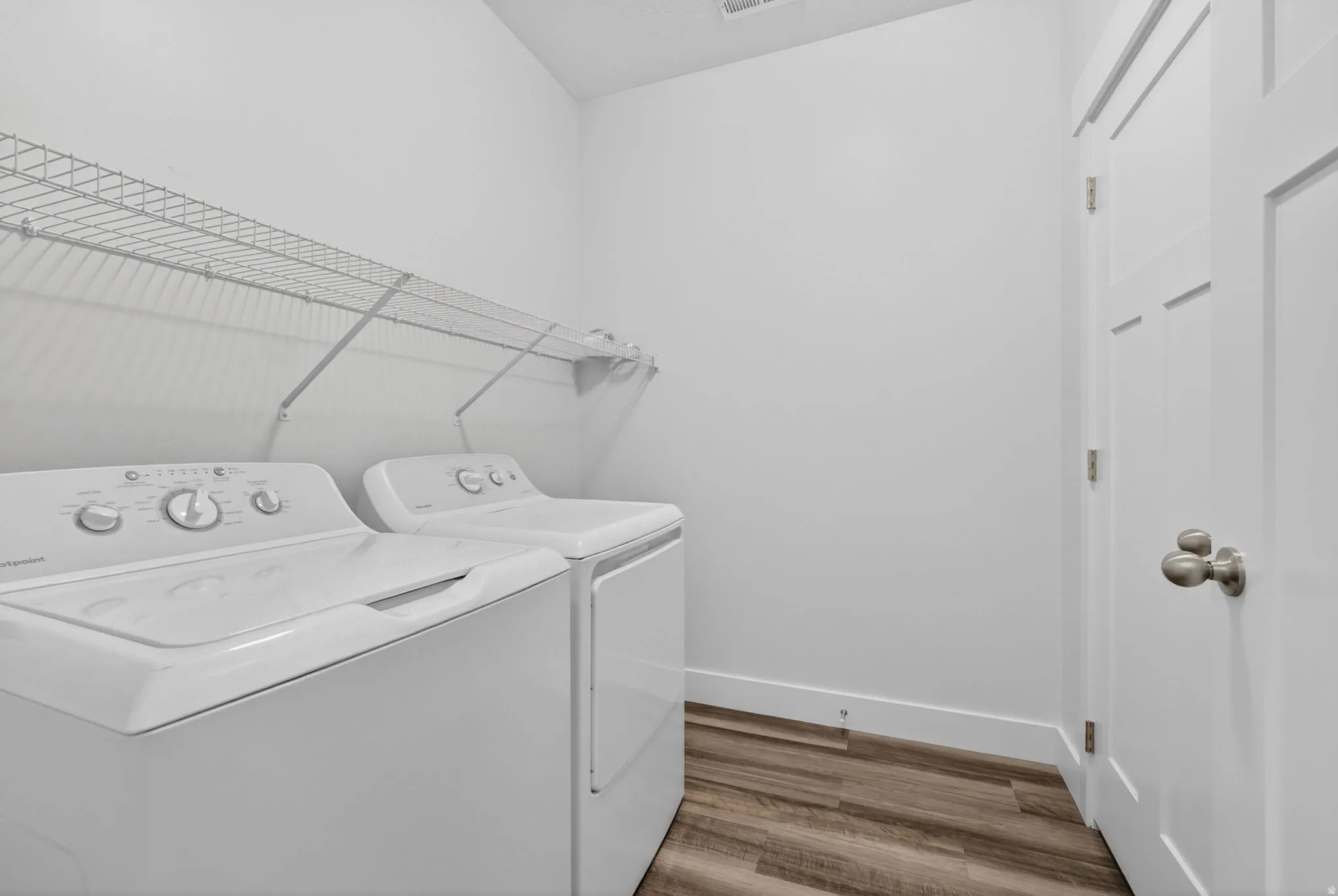Laundry area with light wood-style floors and washer and clothes dryer