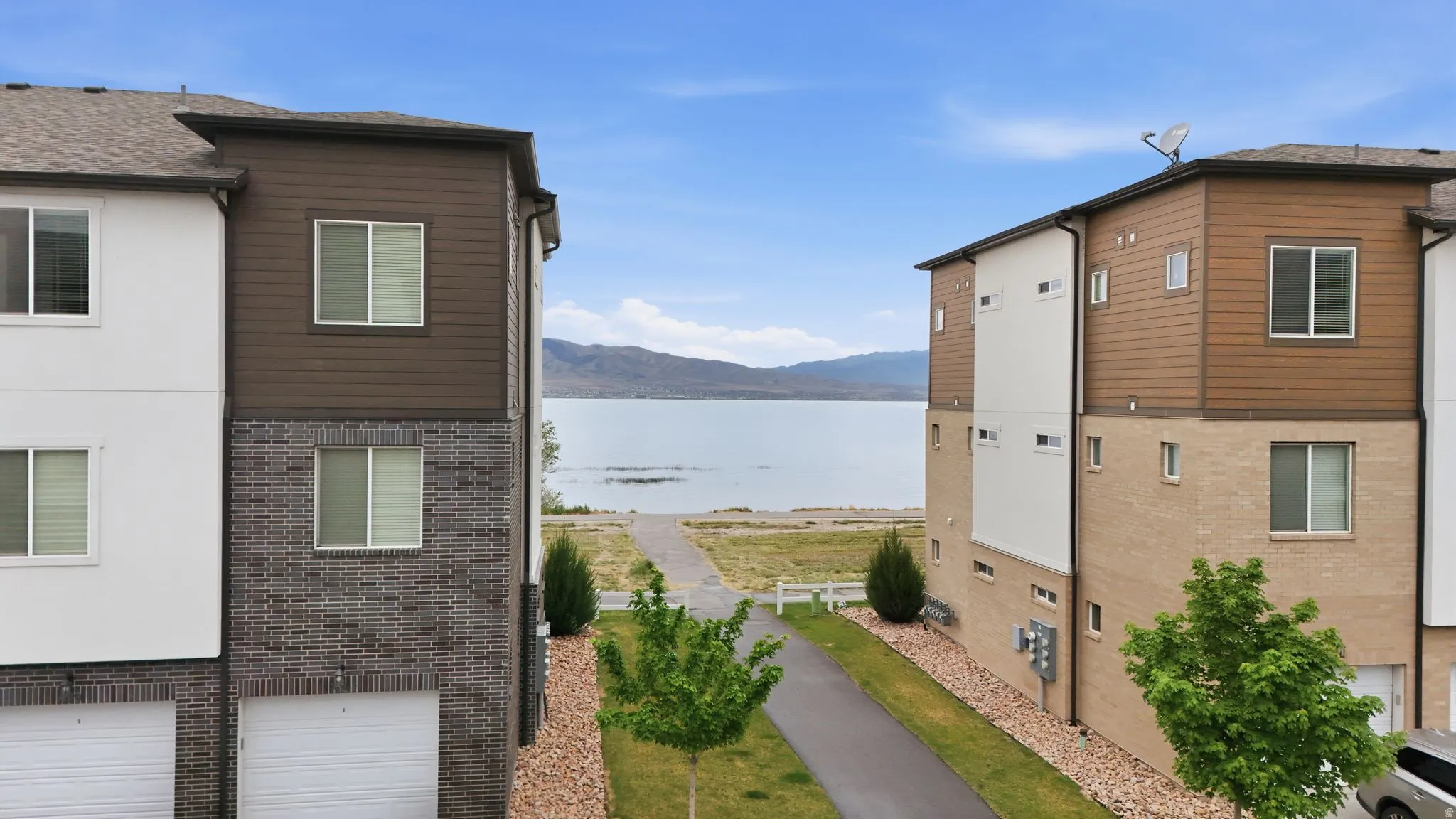 View of side of property with brick siding, a garage, and a water and mountain view