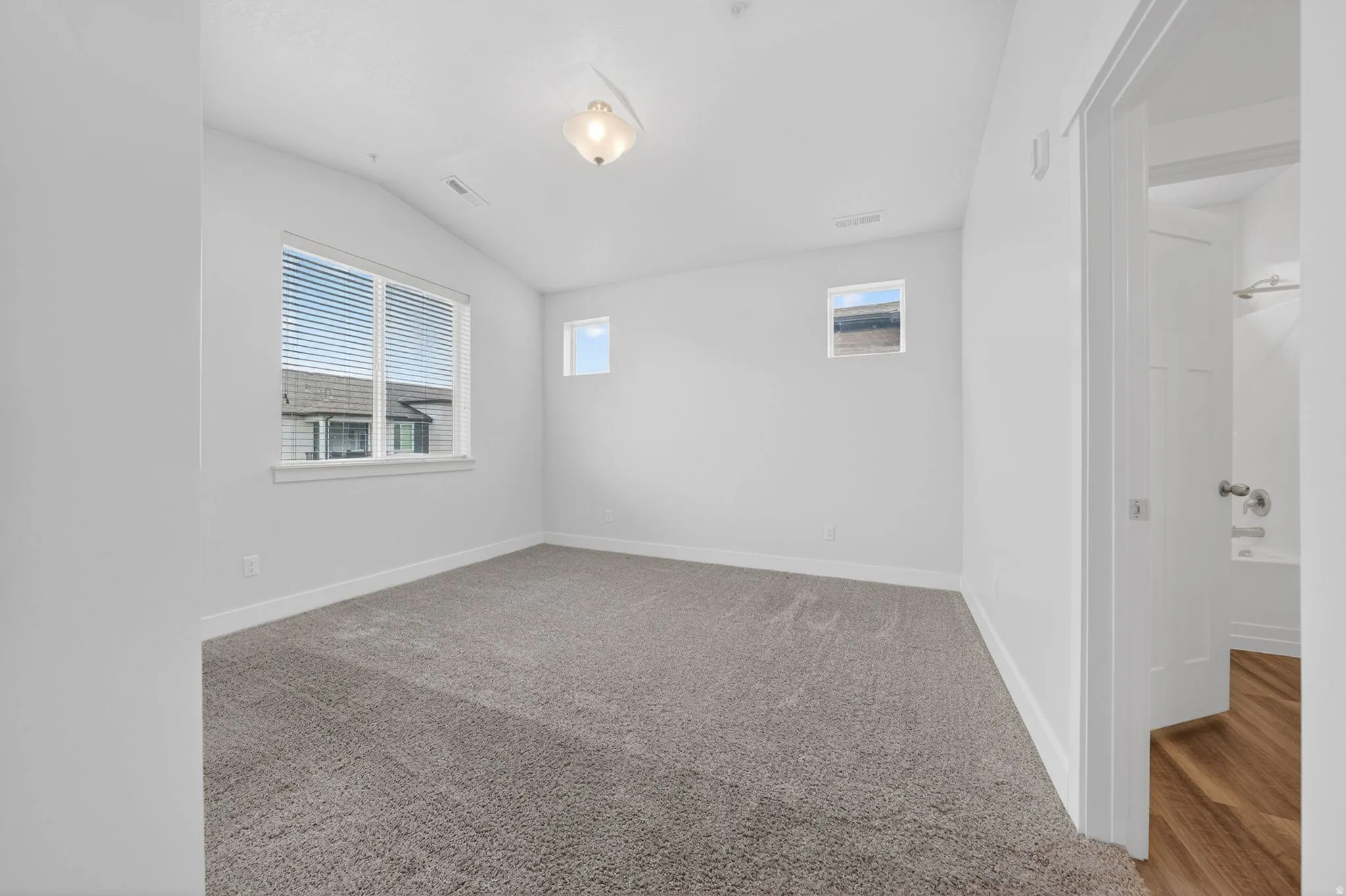 Unfurnished room with lofted ceiling and carpet flooring