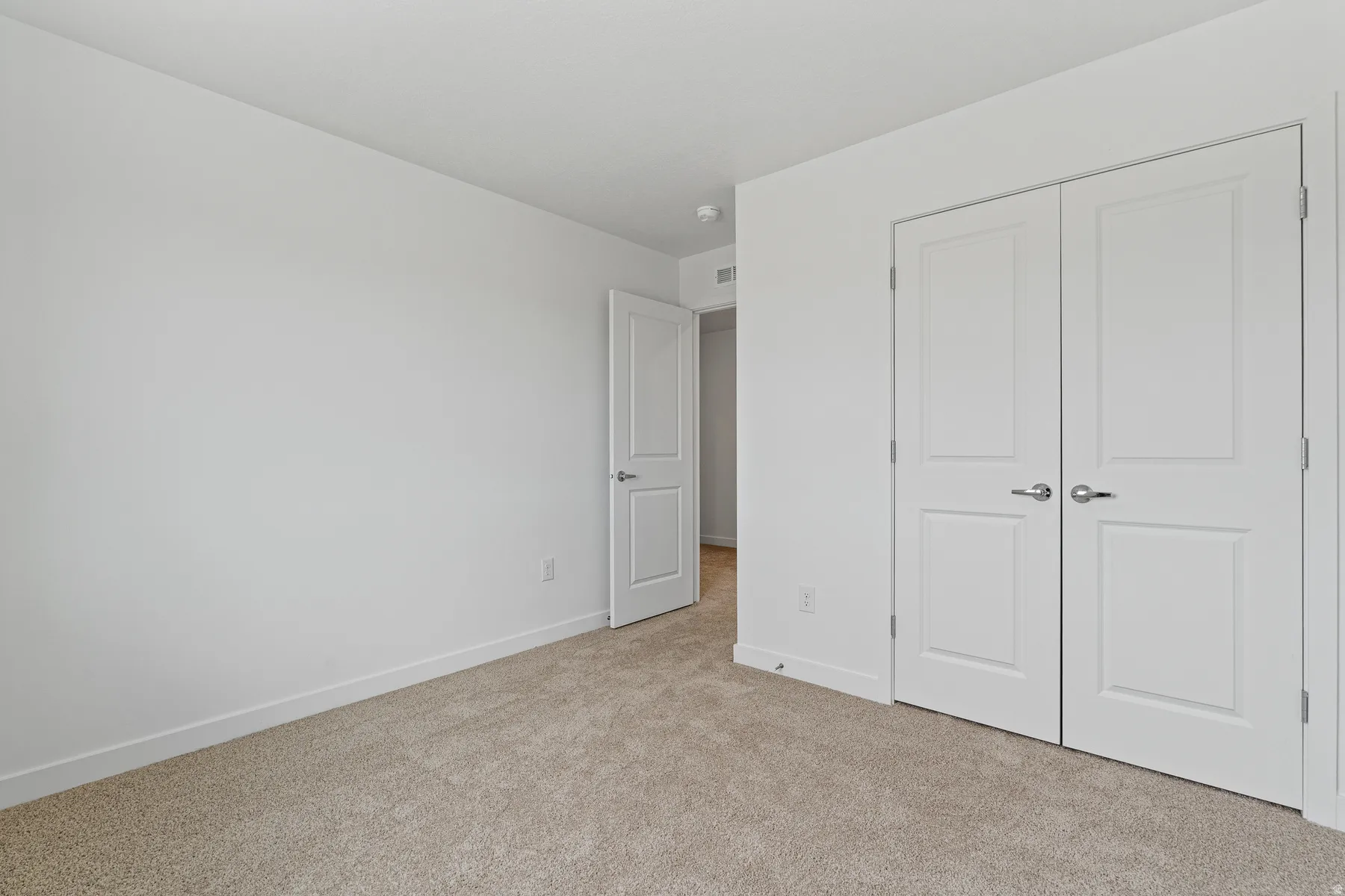 Neutral-toned carpet flooring complementing bright white walls