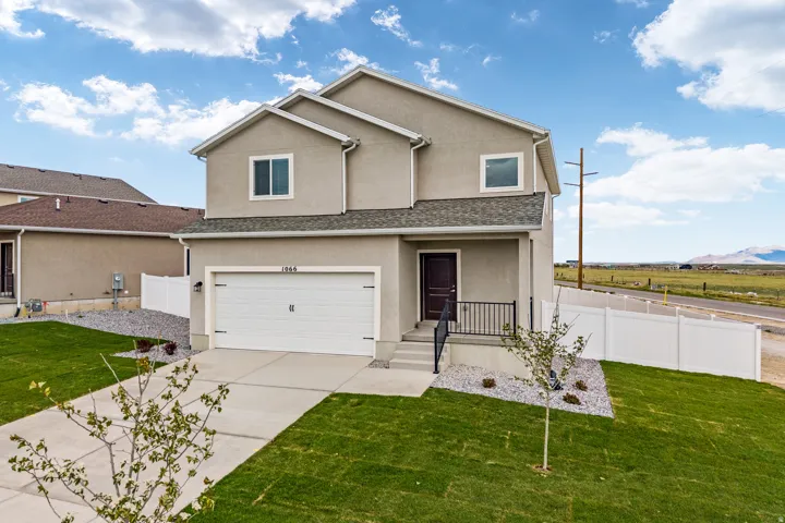 Contemporary two-story residence featuring a stucco exterior, an attached two-car garage, and a covered front entry