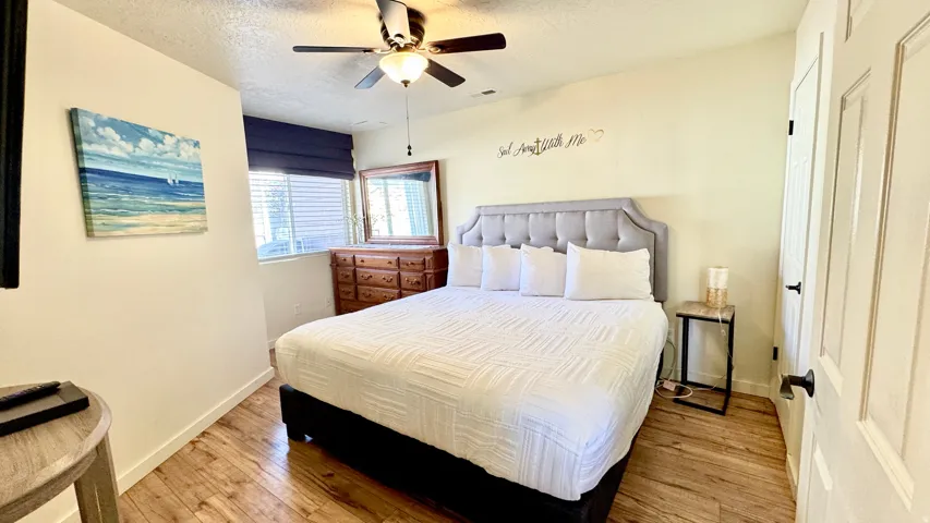 Bedroom featuring a textured ceiling, light wood-style floors, and a ceiling fan