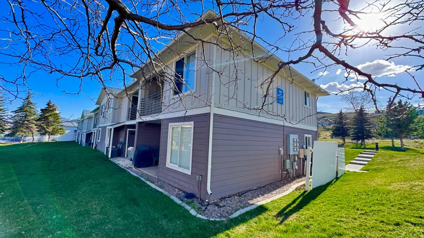 View of home's exterior with a lawn, a balcony, and board and batten siding