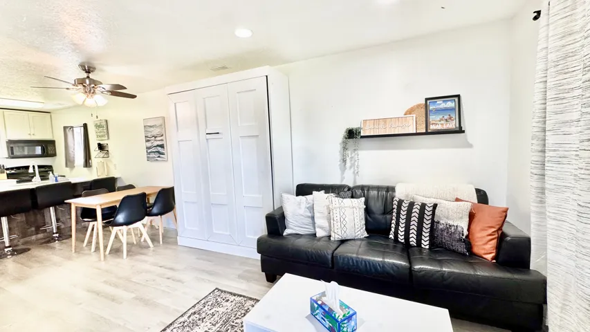 Living area with ceiling fan, light wood-style floors, and recessed lighting