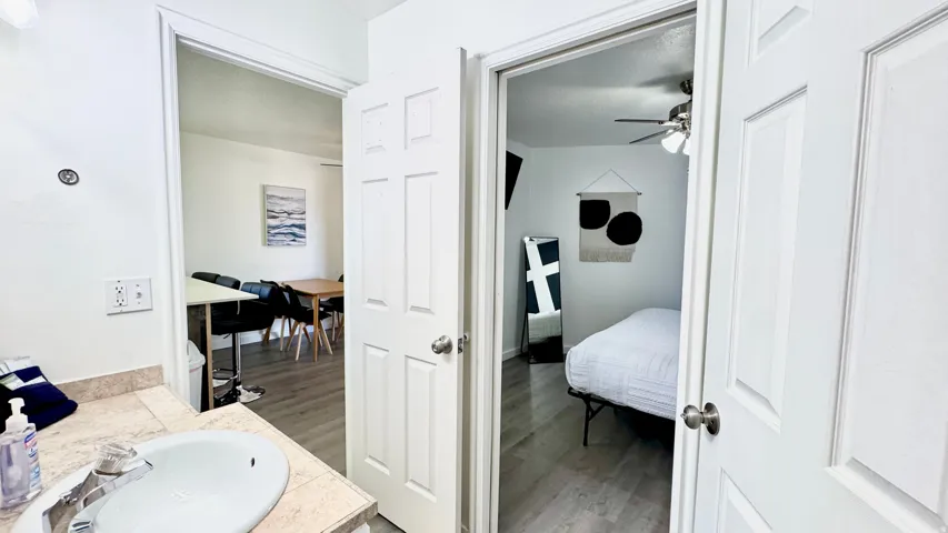 Ensuite bathroom featuring vanity, light wood finished floors, and a ceiling fan
