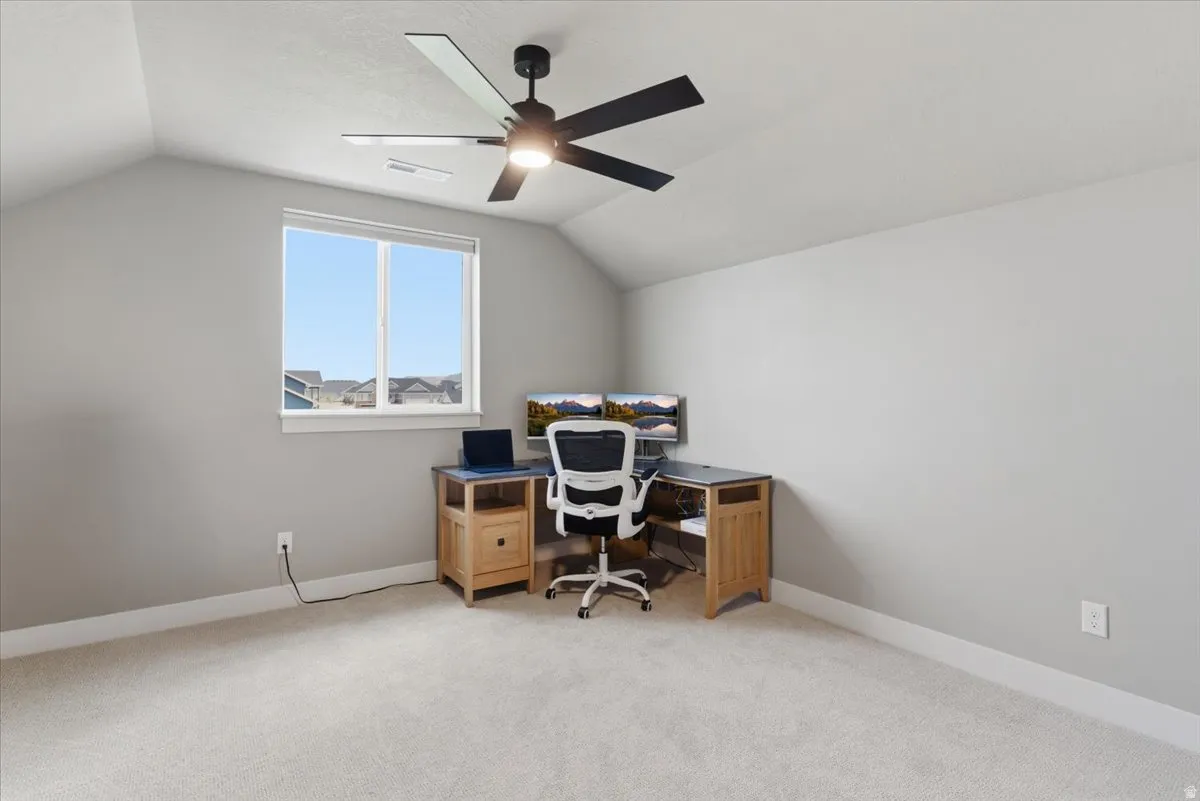 Office area featuring light colored carpet and ceiling fan