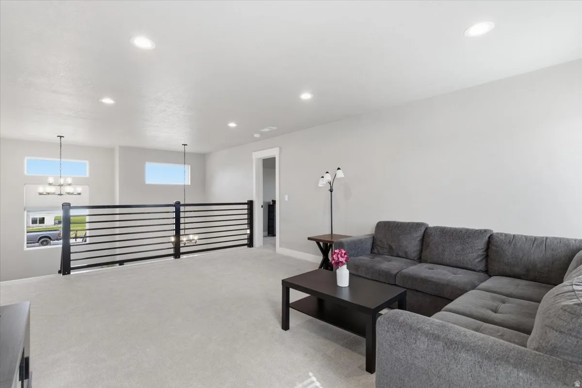 Living room with light colored carpet and a chandelier