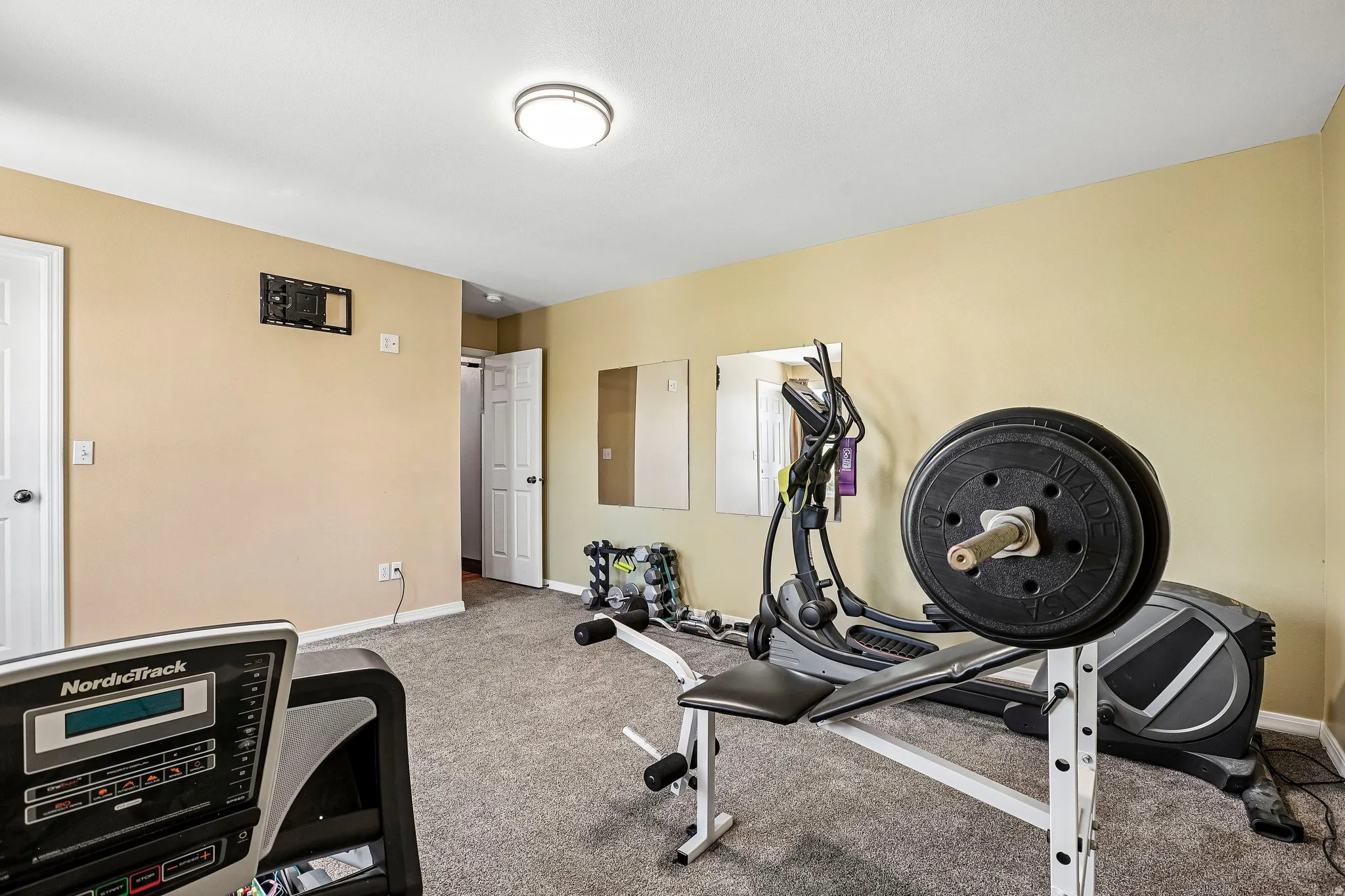 Workout area with light colored carpet and baseboards