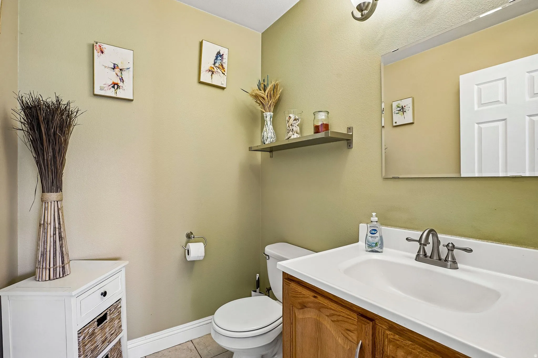 Half bathroom with vanity and light tile patterned floors