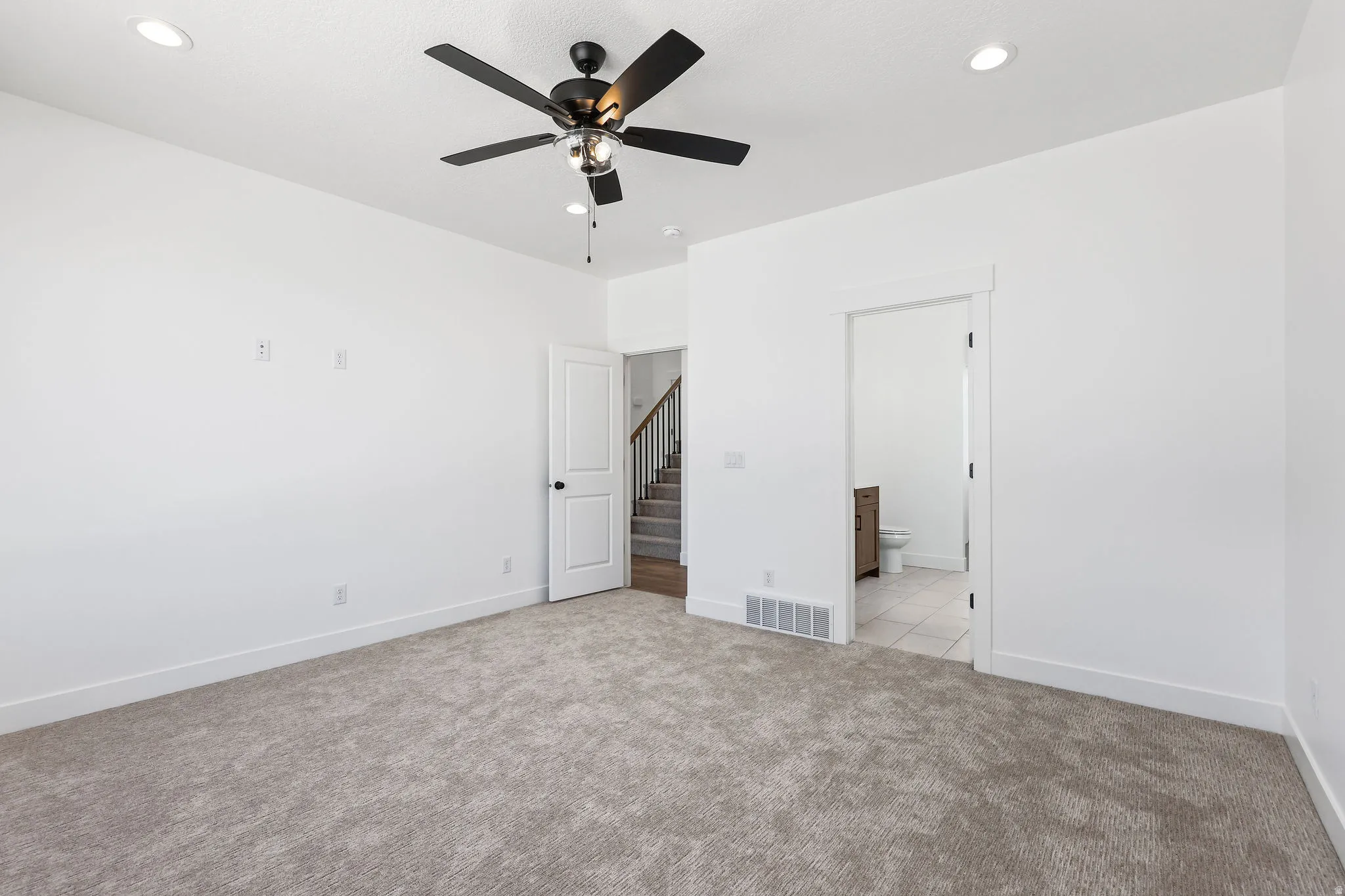 Spacious room featuring neutral carpeting, a ceiling fan with integrated lighting, recessed lighting, and crisp white walls