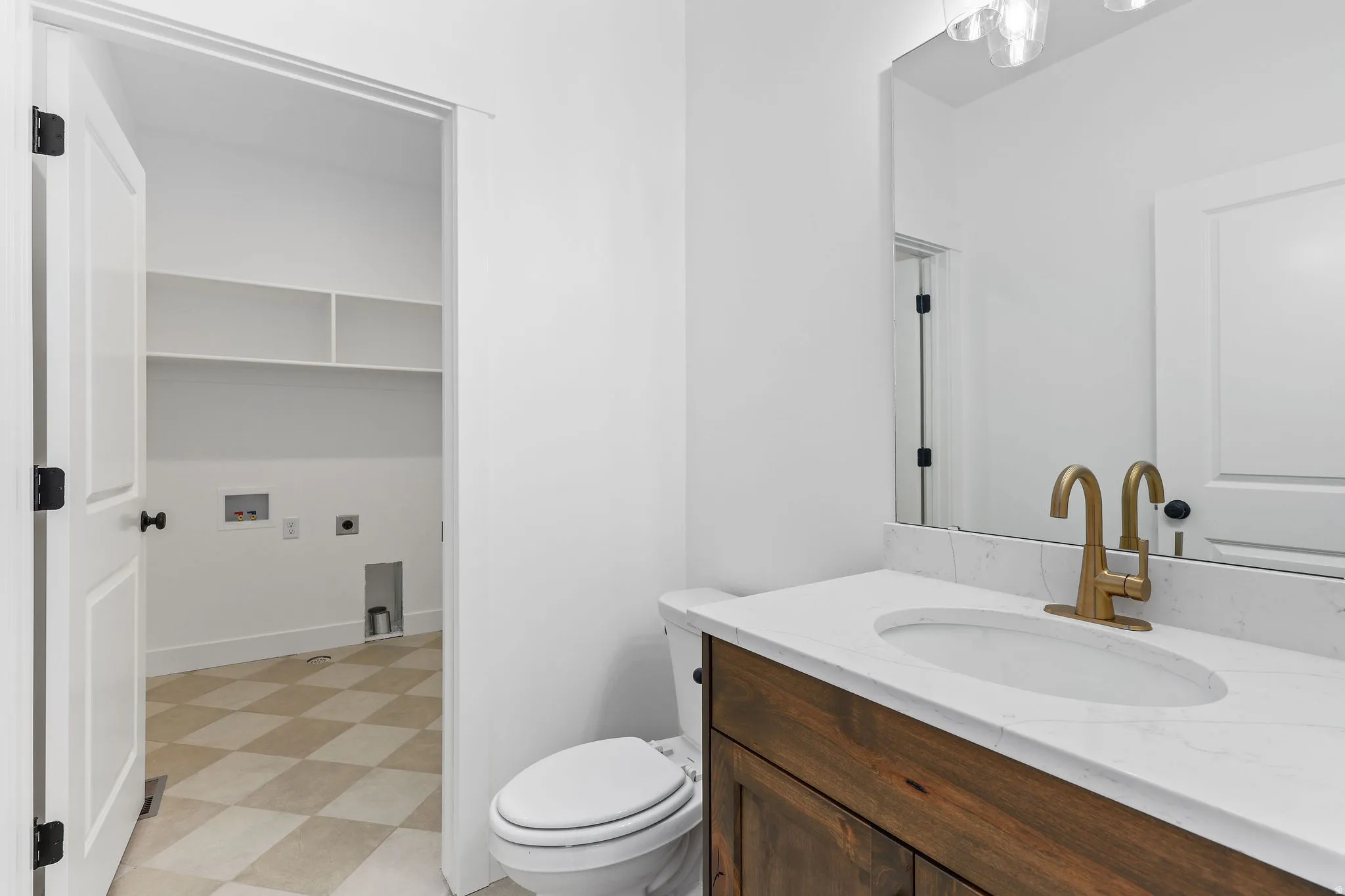 Bathroom vanity featuring a wood-finish cabinet, a white countertop with an integrated sink, and a gold-tone faucet
