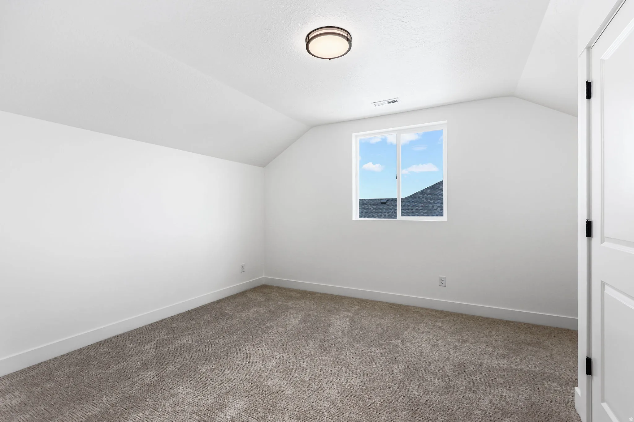 Carpeted room featuring a single window, a contemporary flush mount light fixture, crisp white walls, and white trim
