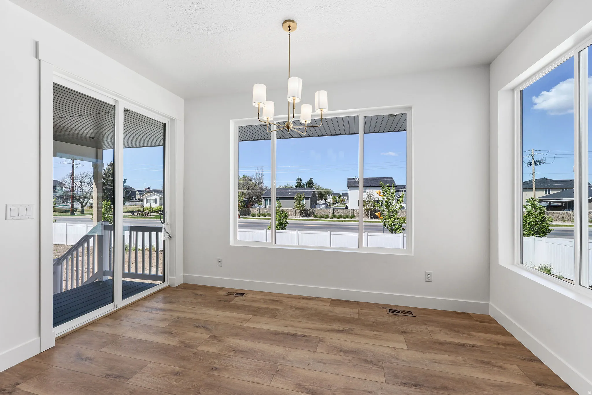 Bright interior space featuring wood-finish flooring and a contemporary chandelier
