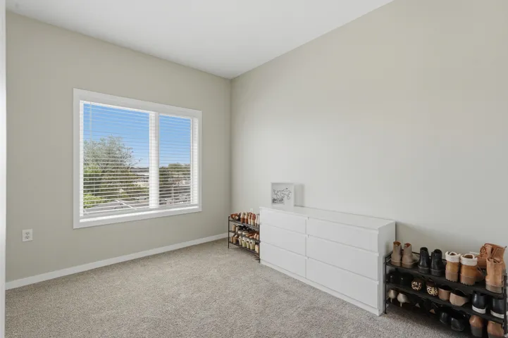 Bedroom featuring light colored carpet and baseboards