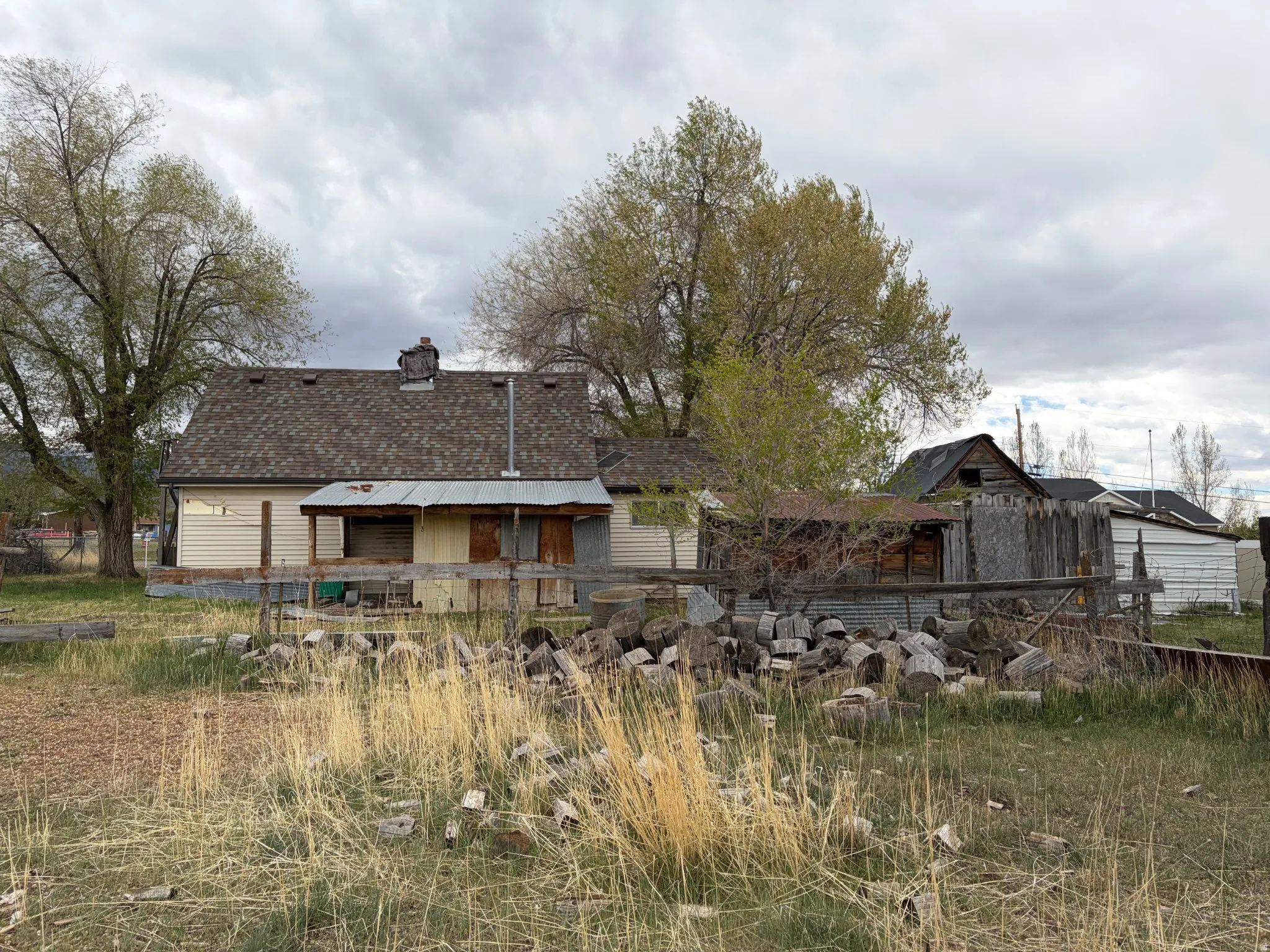 Rear view of house featuring a chimney and a shingled roof