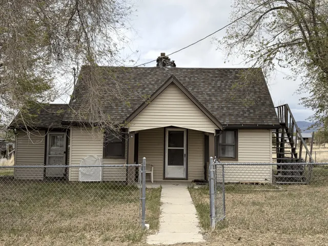 View of front of house with a shingled roof, a fenced front yard, a gate, and a porch