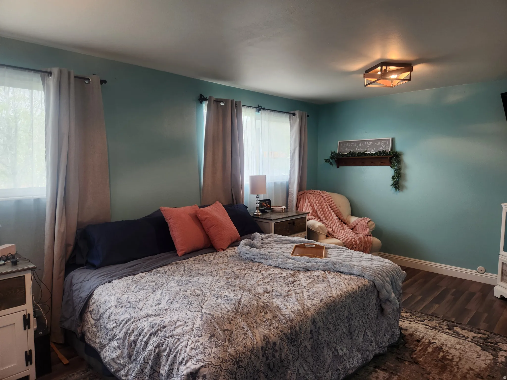 Bedroom with dark wood-style flooring and baseboards