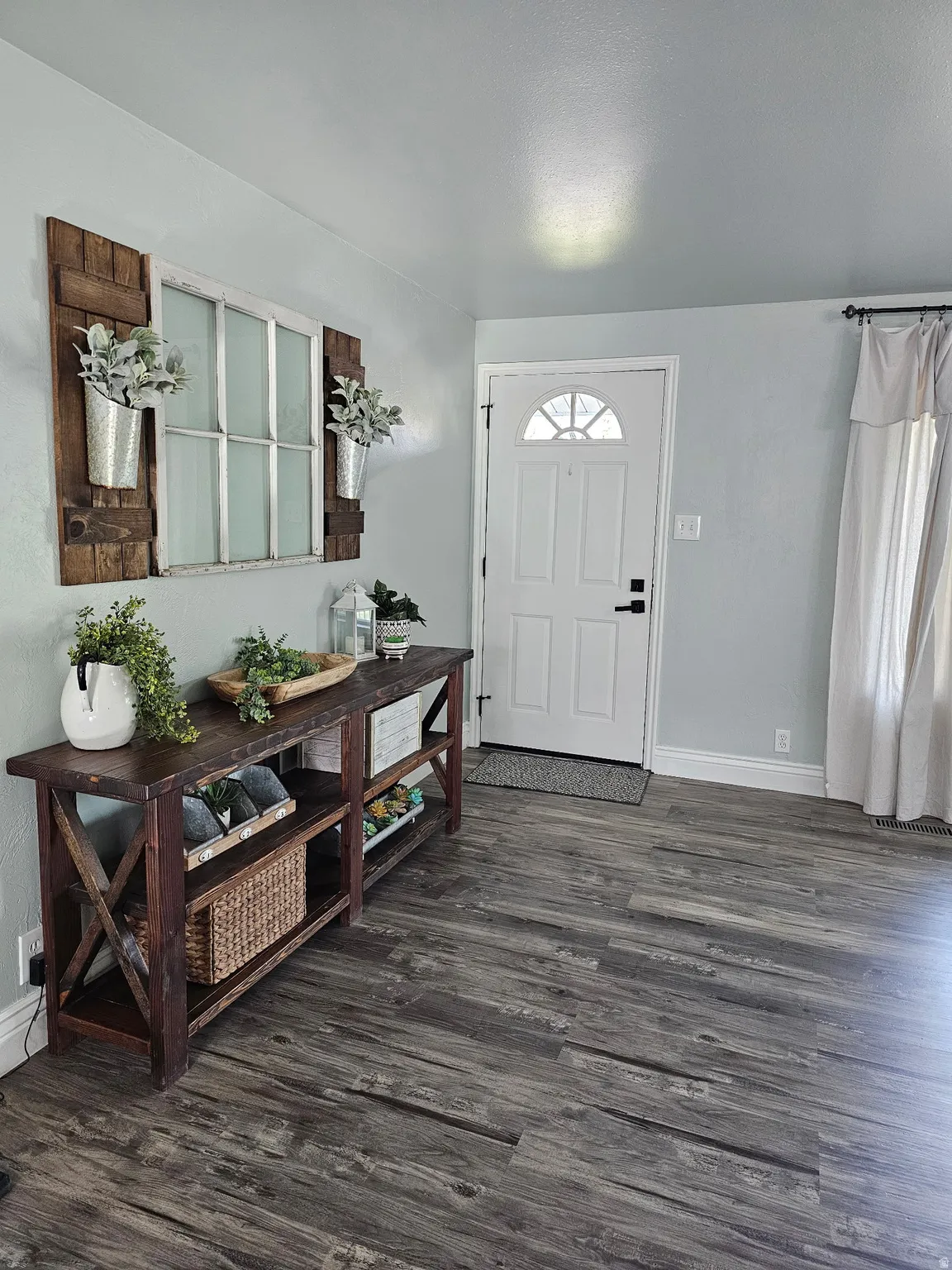 Foyer with baseboards and dark wood-style floors