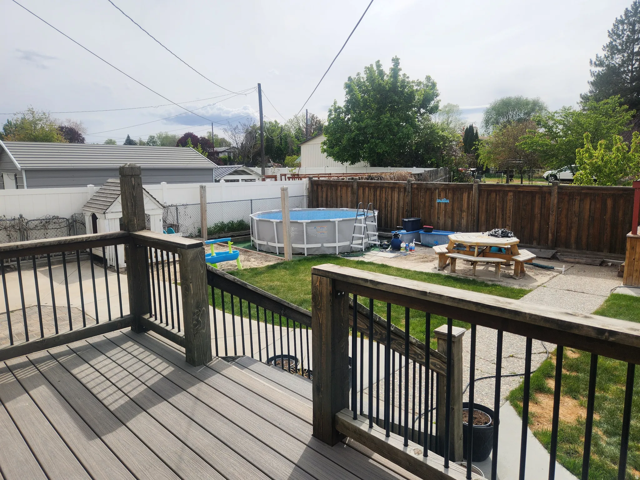 Wooden terrace with a patio and a fenced backyard