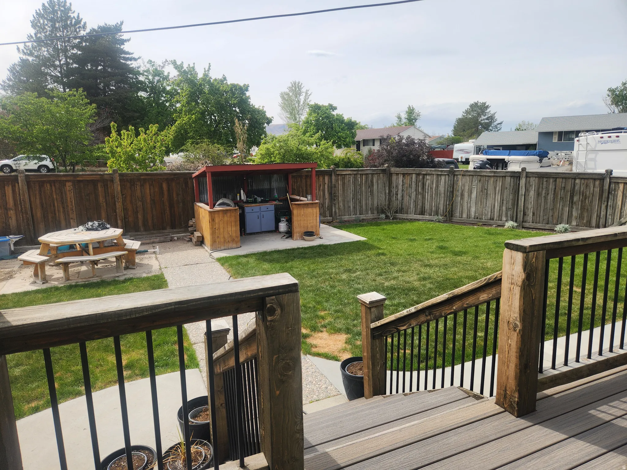 Wooden deck with a patio area and a fenced backyard