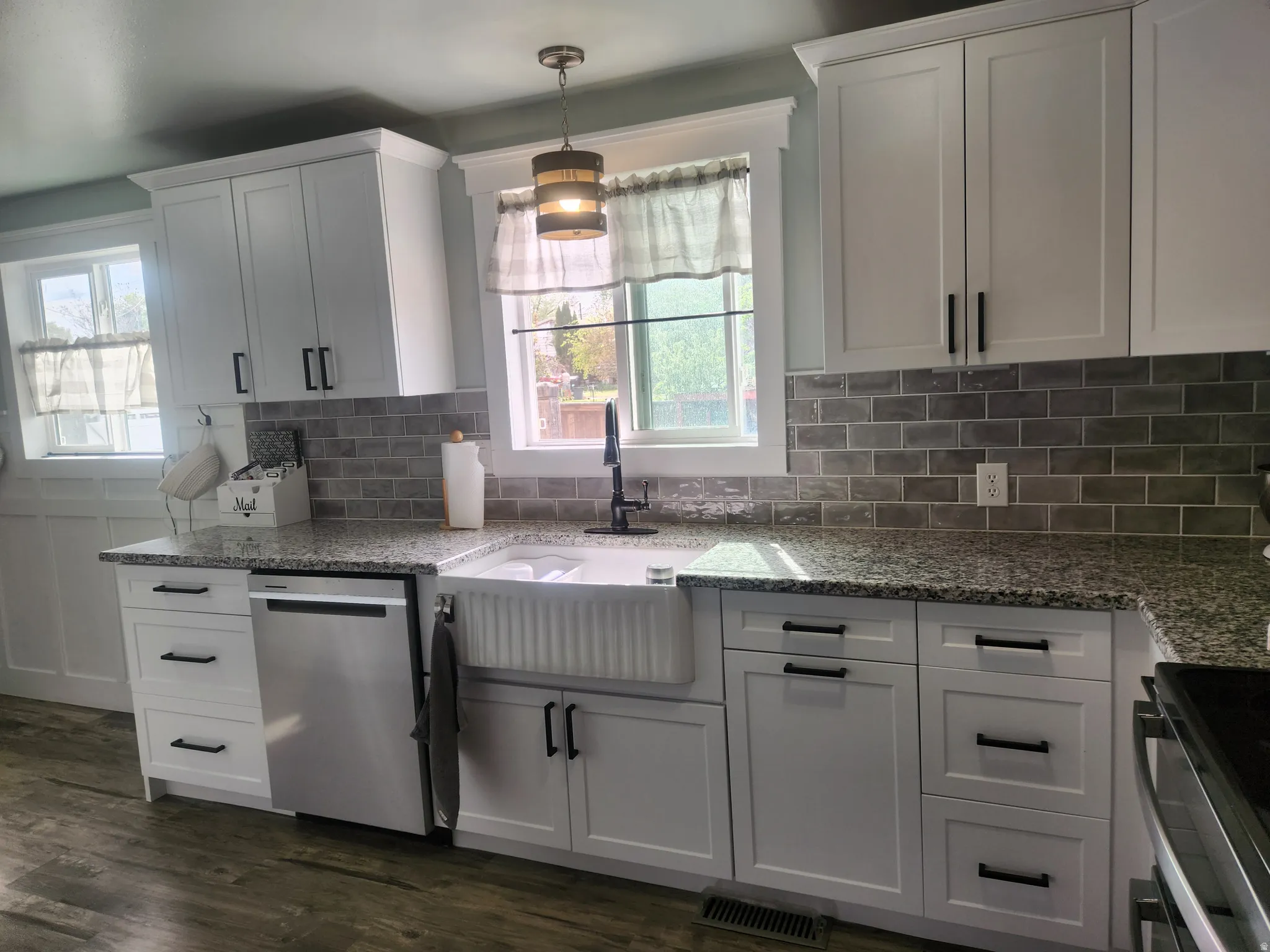Kitchen with stainless steel appliances, light stone countertops, and white cabinets