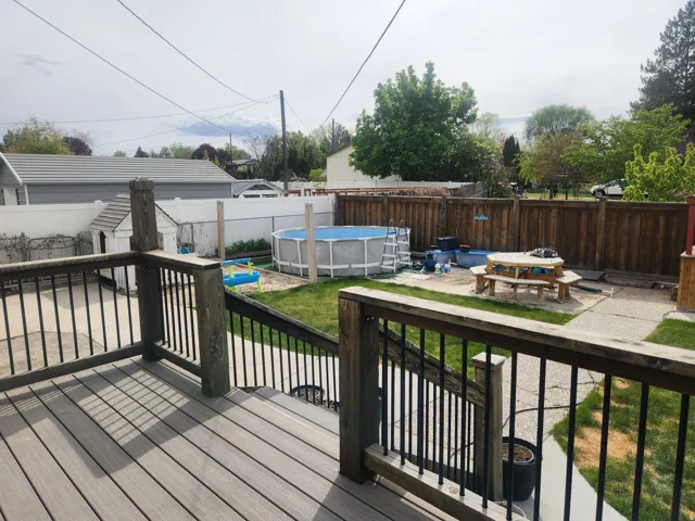 Wooden terrace with a patio and a fenced backyard