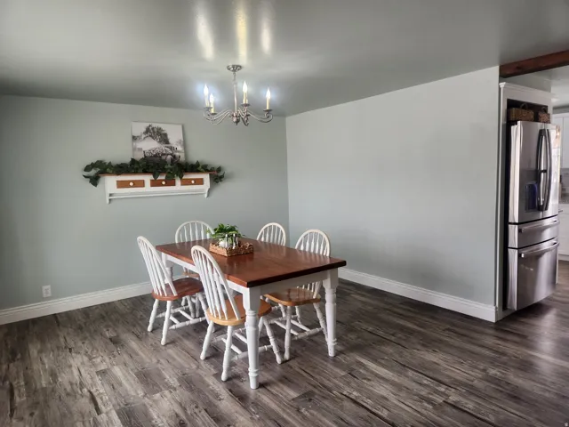 Dining space featuring dark wood-type flooring and hanging lights