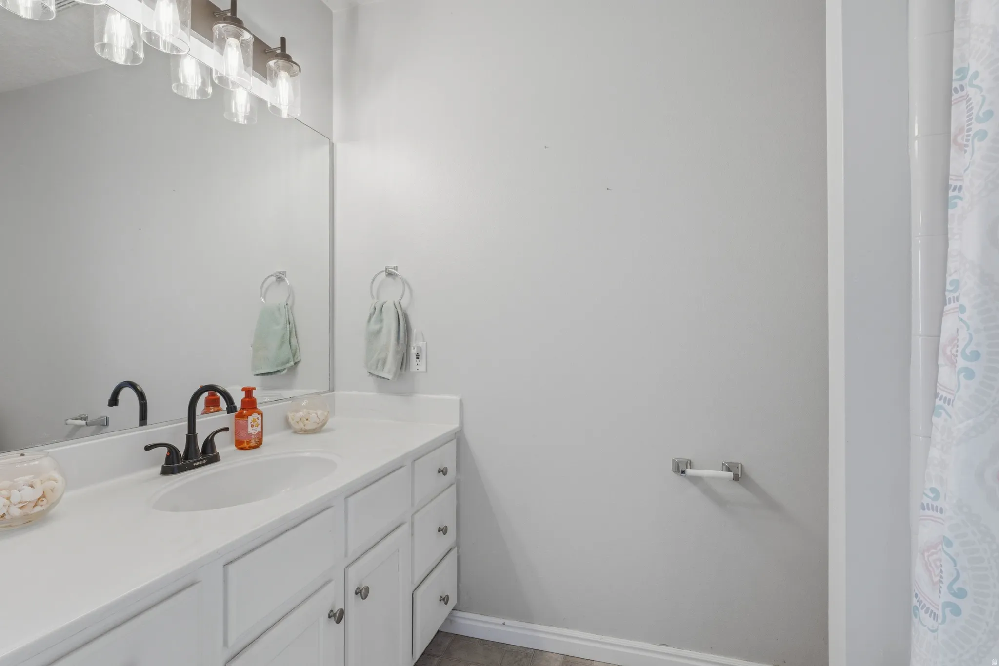 Full bath featuring vanity and curtained shower