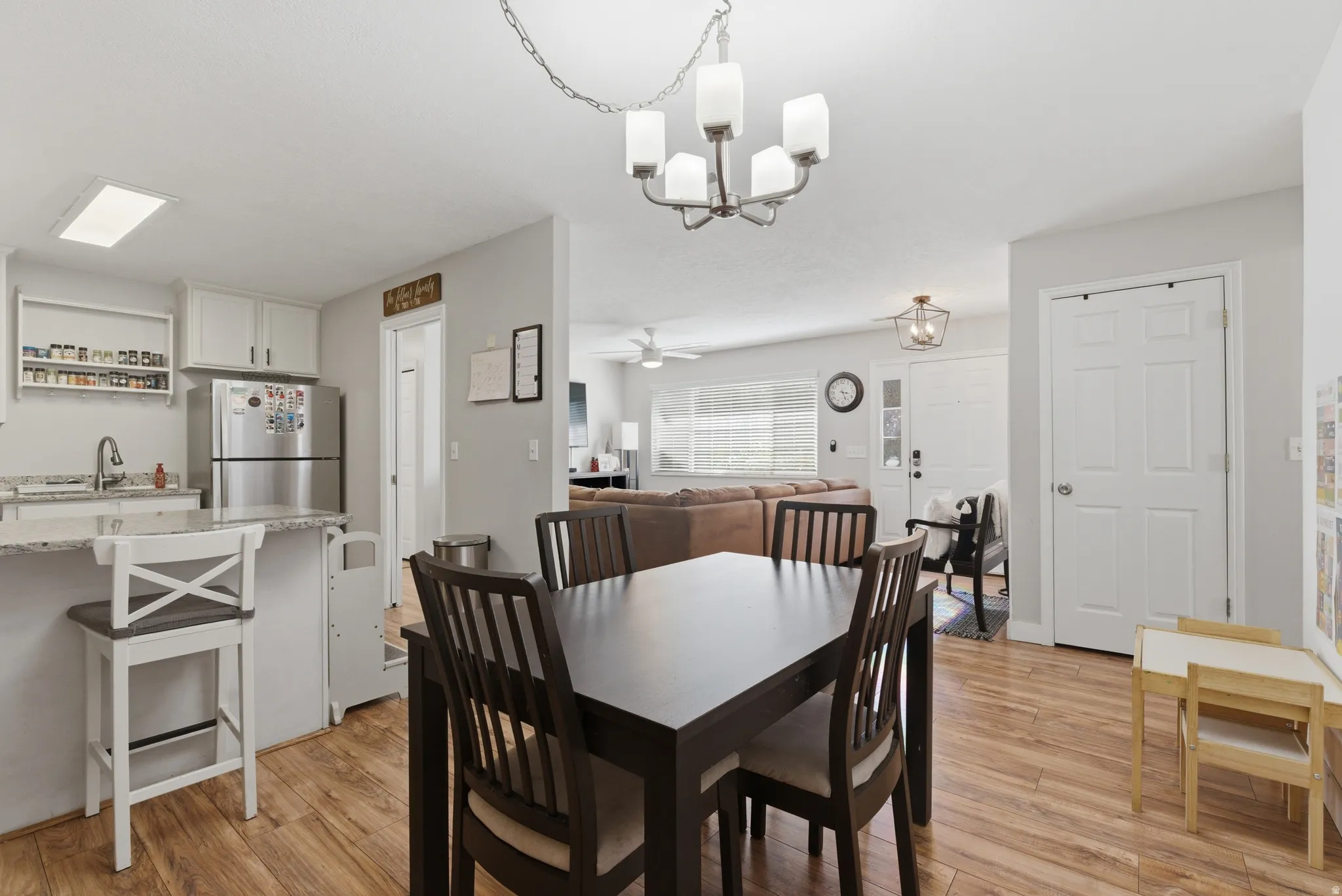 Dining area with light wood-style flooring, a ceiling fan, and hanging lights