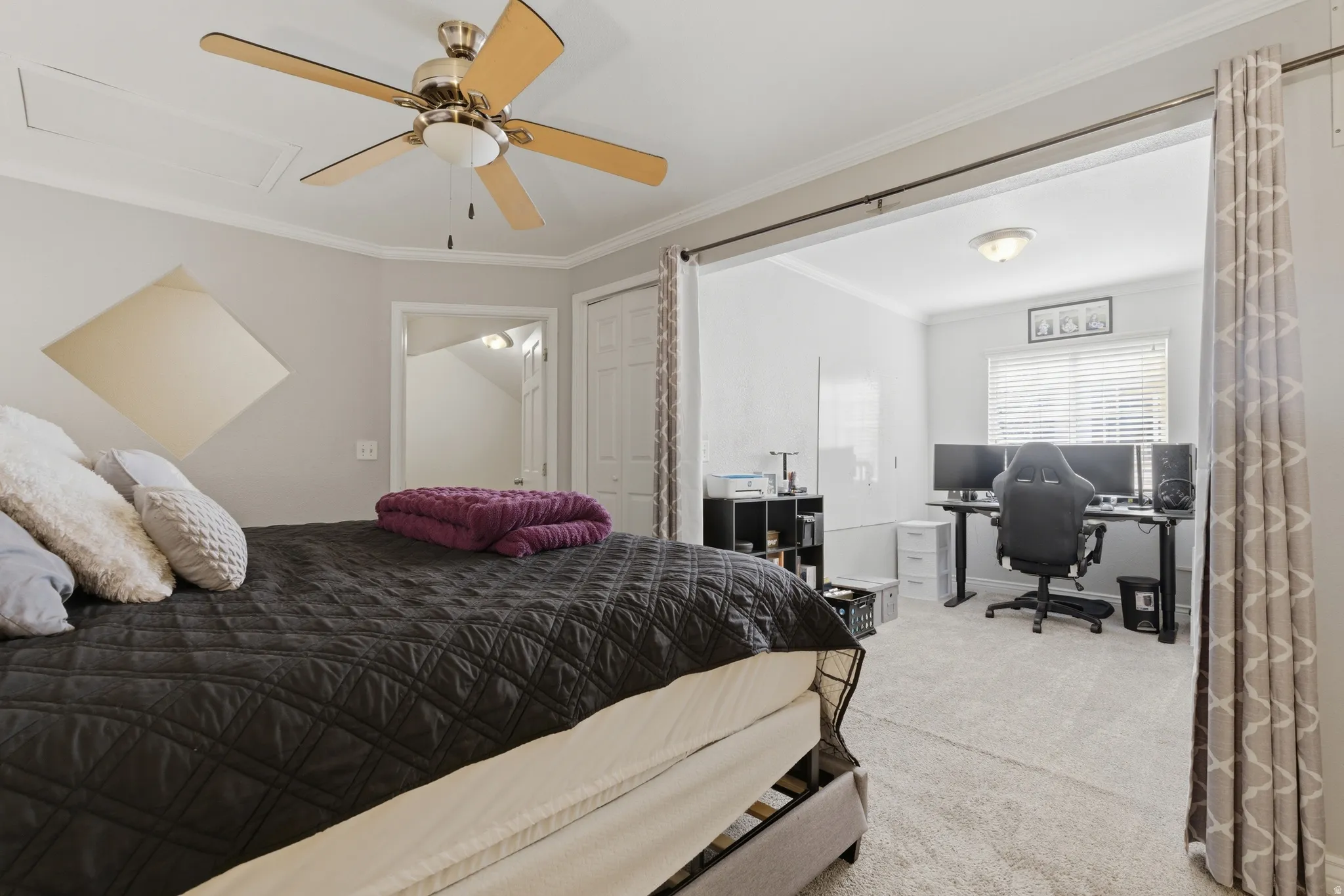 Bedroom featuring ornamental molding, light carpet, an office area, and ceiling fan
