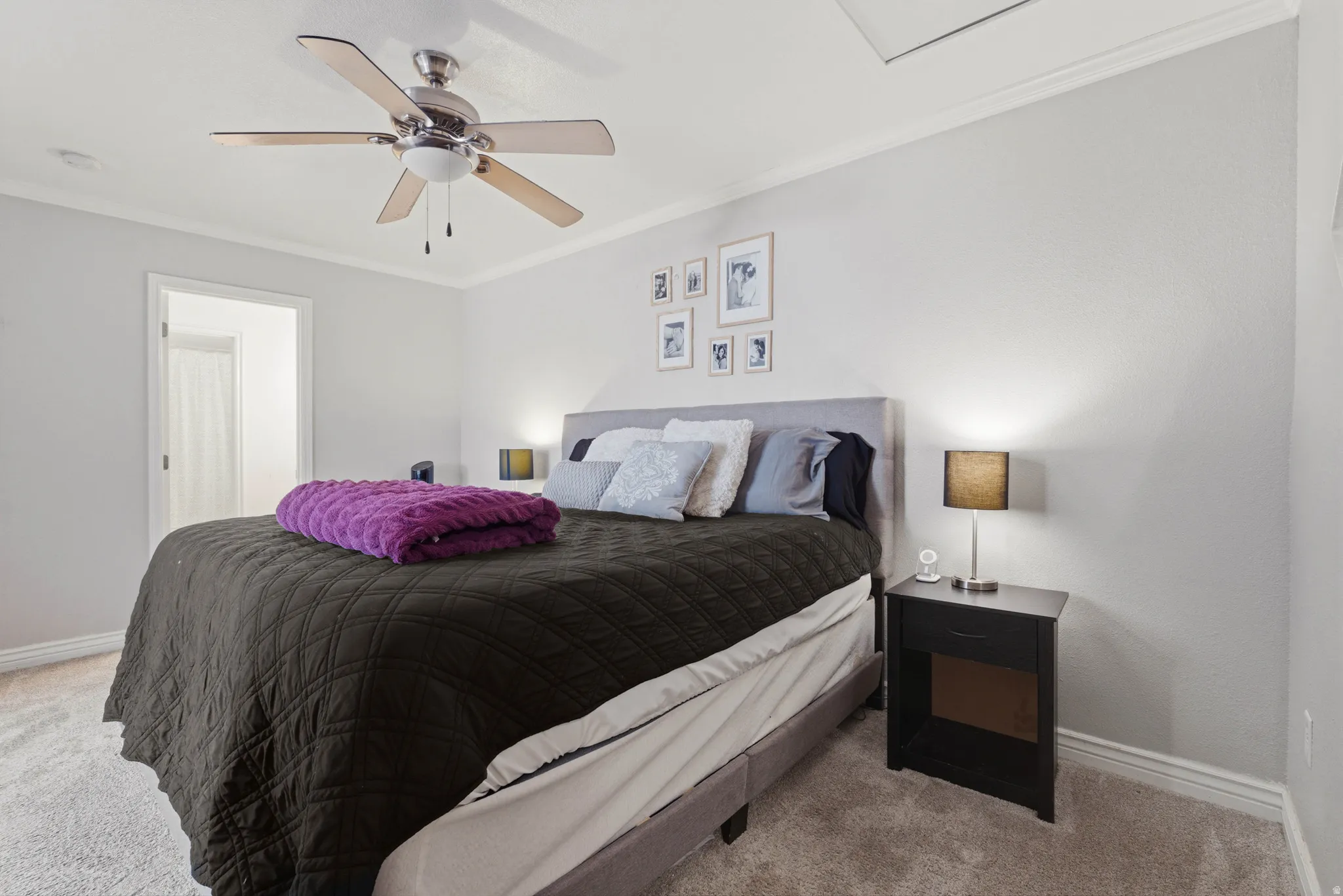 Carpeted bedroom featuring ornamental molding and ceiling fan