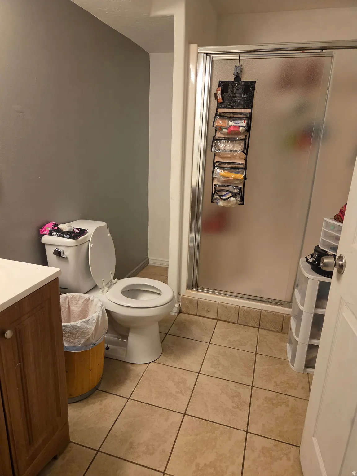 Tile flooring with shower enclosure featuring a framed frosted glass door