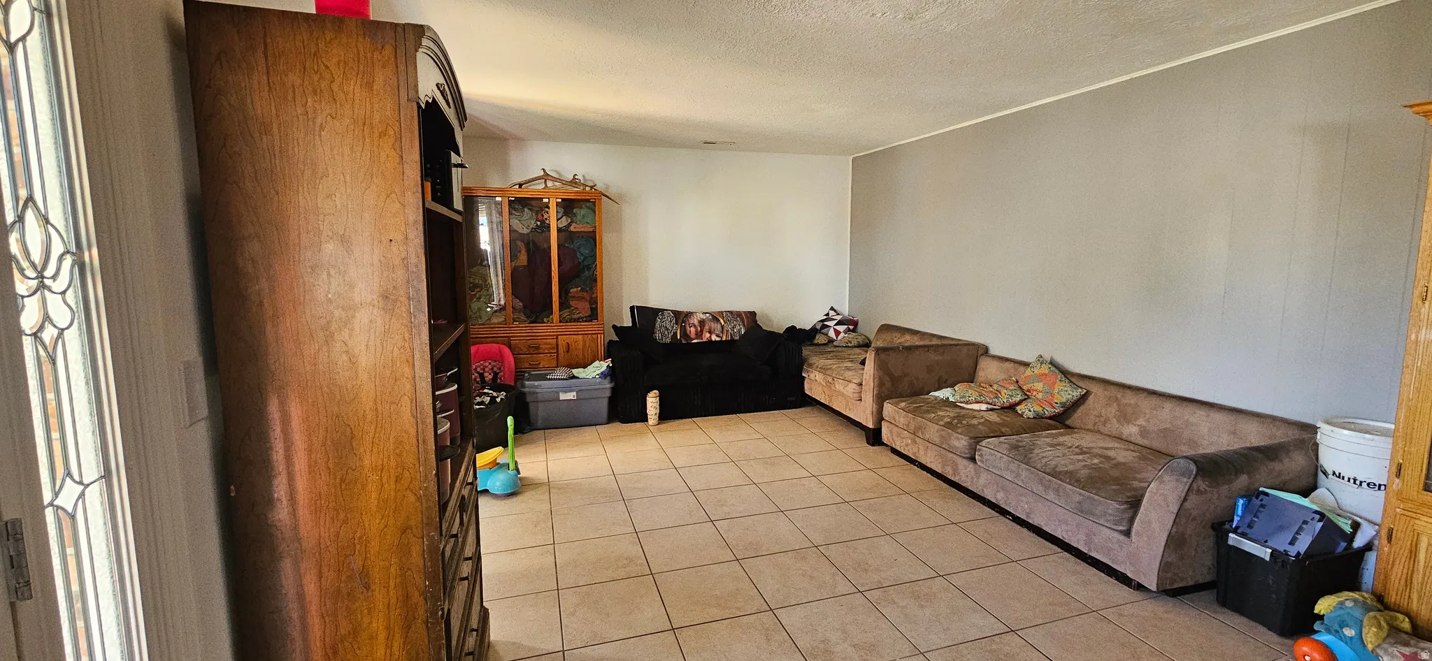 Living area with light tile patterned flooring and a textured ceiling