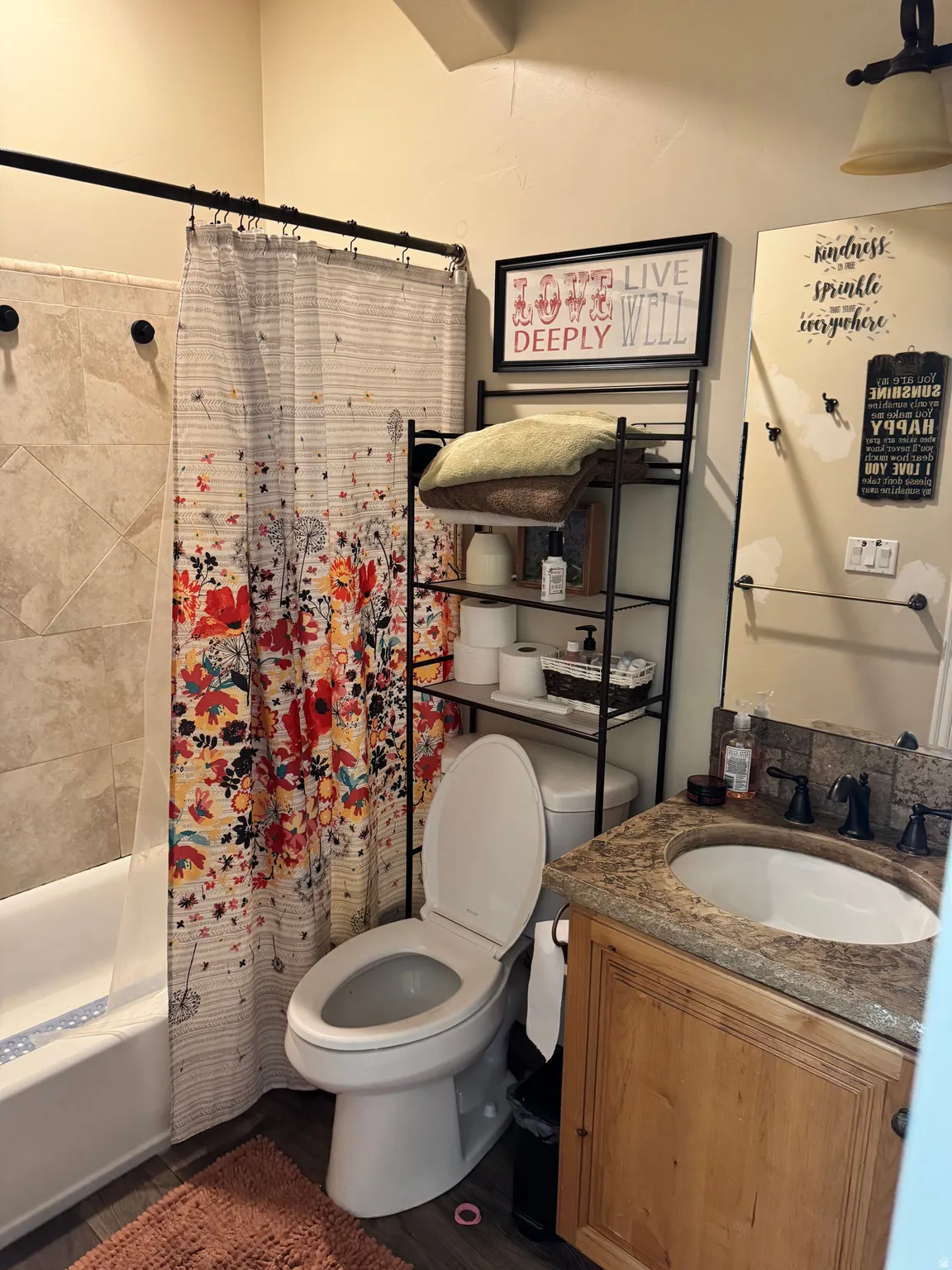 Bathroom with vanity, shower / tub combo, and dark wood-style flooring