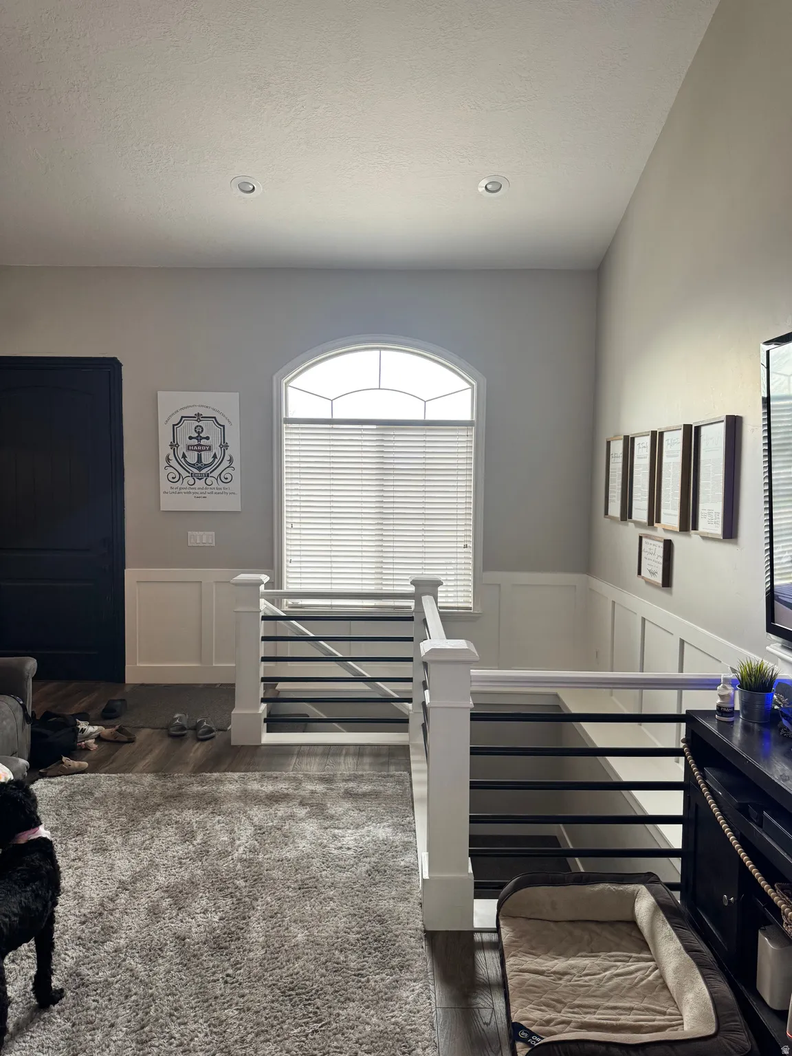 Staircase featuring wainscoting, a decorative wall, and a textured ceiling