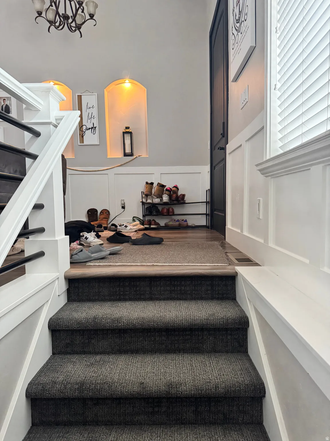 Stairs featuring a decorative wall and a wainscoted wall