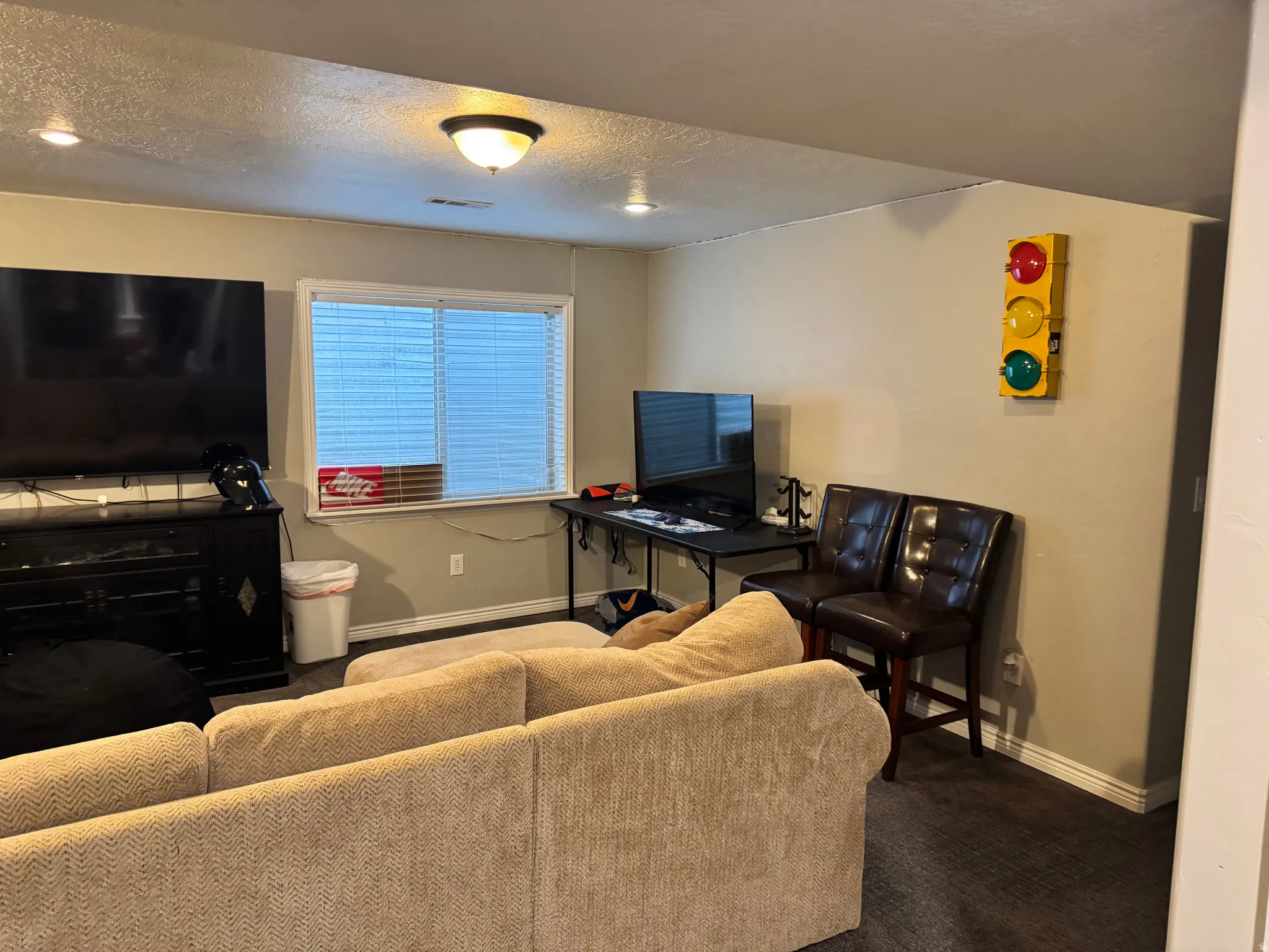Living area with a textured ceiling and carpet floors