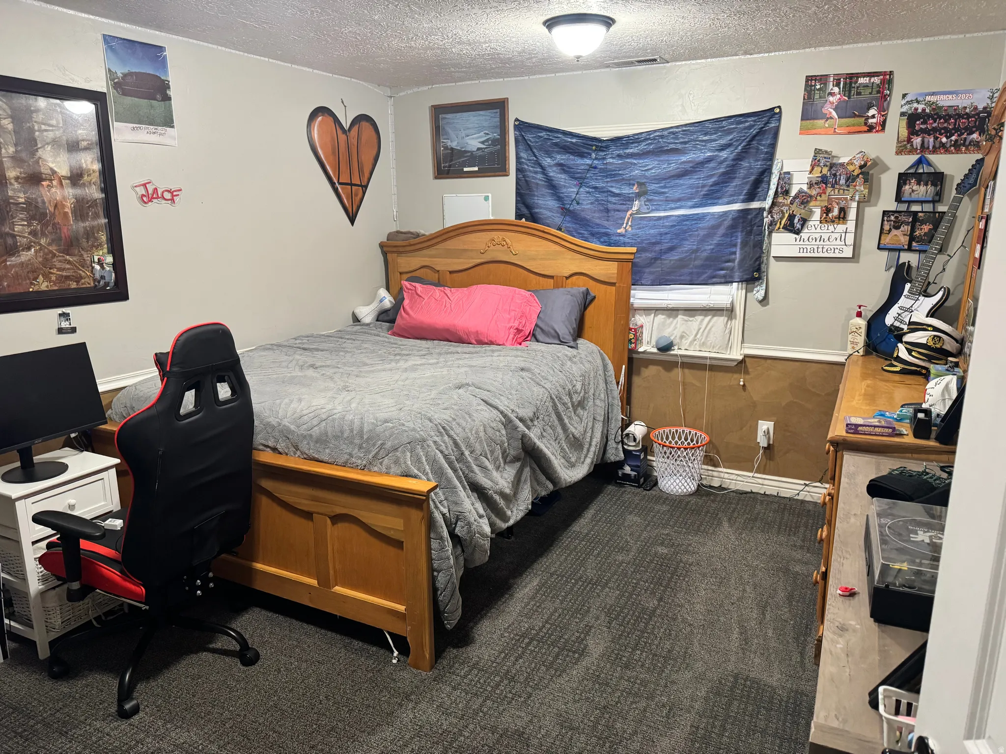 Bedroom featuring dark carpet, a textured ceiling, and an office area