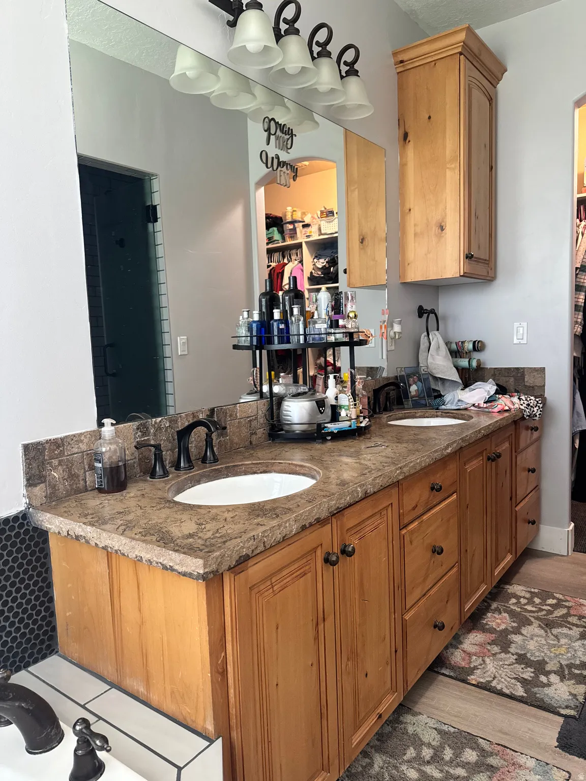Double vanity with integrated sinks, textured countertop, and dark bronze fixtures